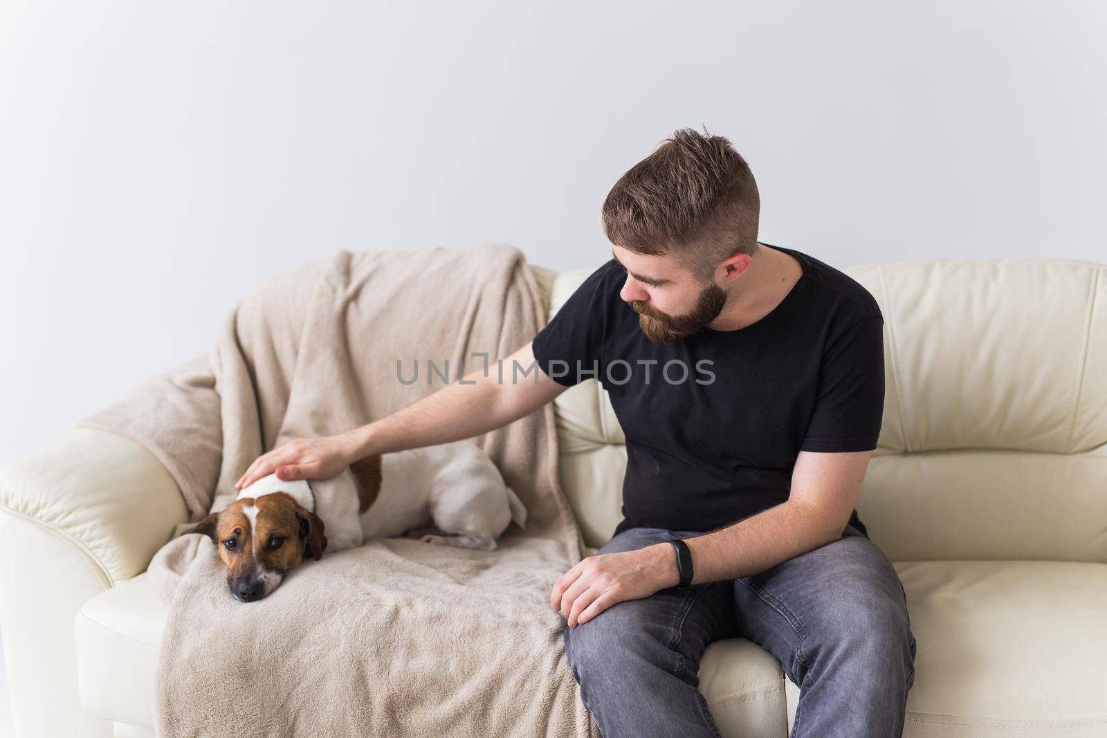 Man with cute dog jack russell terrier on the couch. Pets and home concept. by Satura86