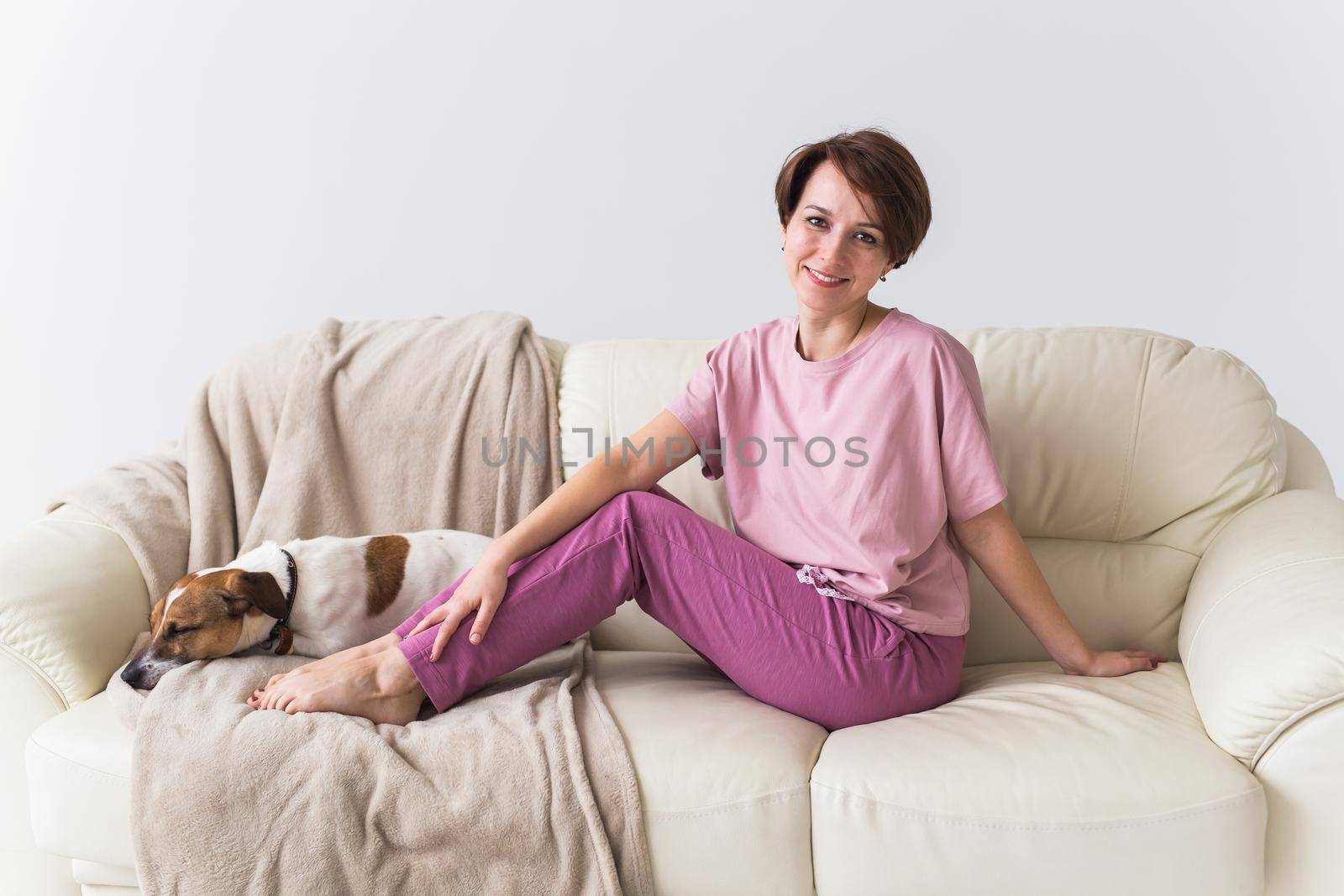 Young attractive woman dressed in beautiful colorful pajama posing as a model in her living room. Comfortable sleepwear, home relaxation and female fashion concept