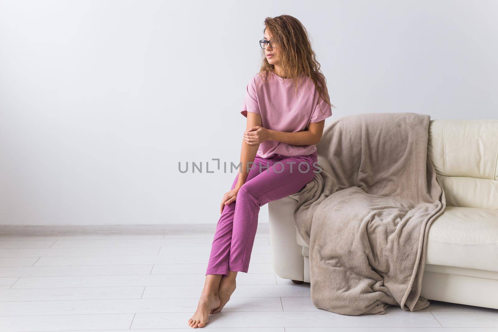 Young attractive woman dressed in beautiful colorful pajama posing as a model in her living room. Comfortable sleepwear, home relaxation and female fashion concept