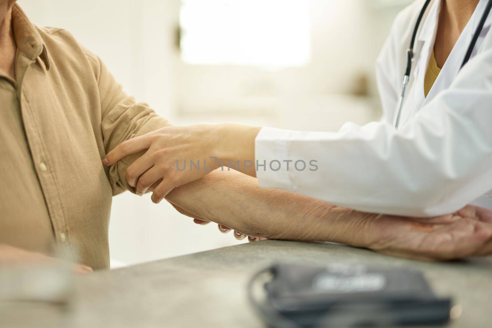 Fragment photo of medical worker in white uniform rolling up the sleeve of eldelry gentleman