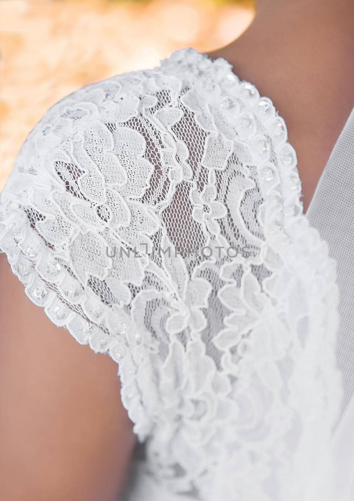 Part of the wedding dress on the bride s shoulder, close-up.