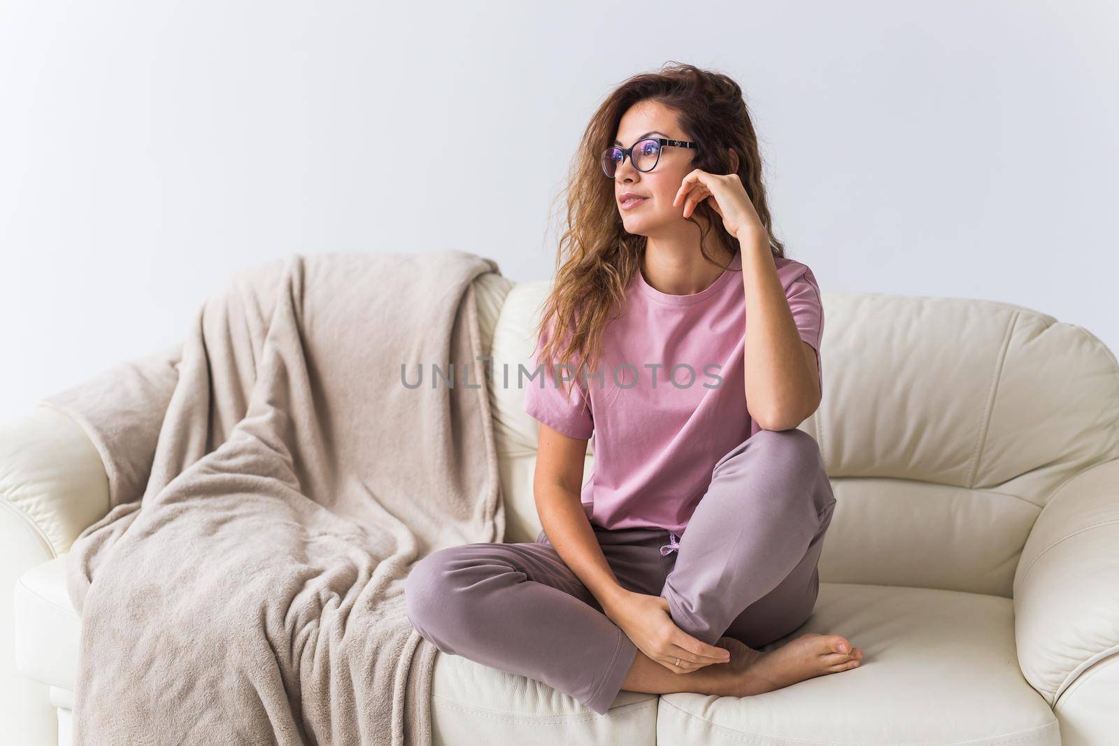 Young attractive woman dressed in beautiful colorful pajama posing as a model in her living room. Comfortable sleepwear, home relaxation and female fashion concept. by Satura86