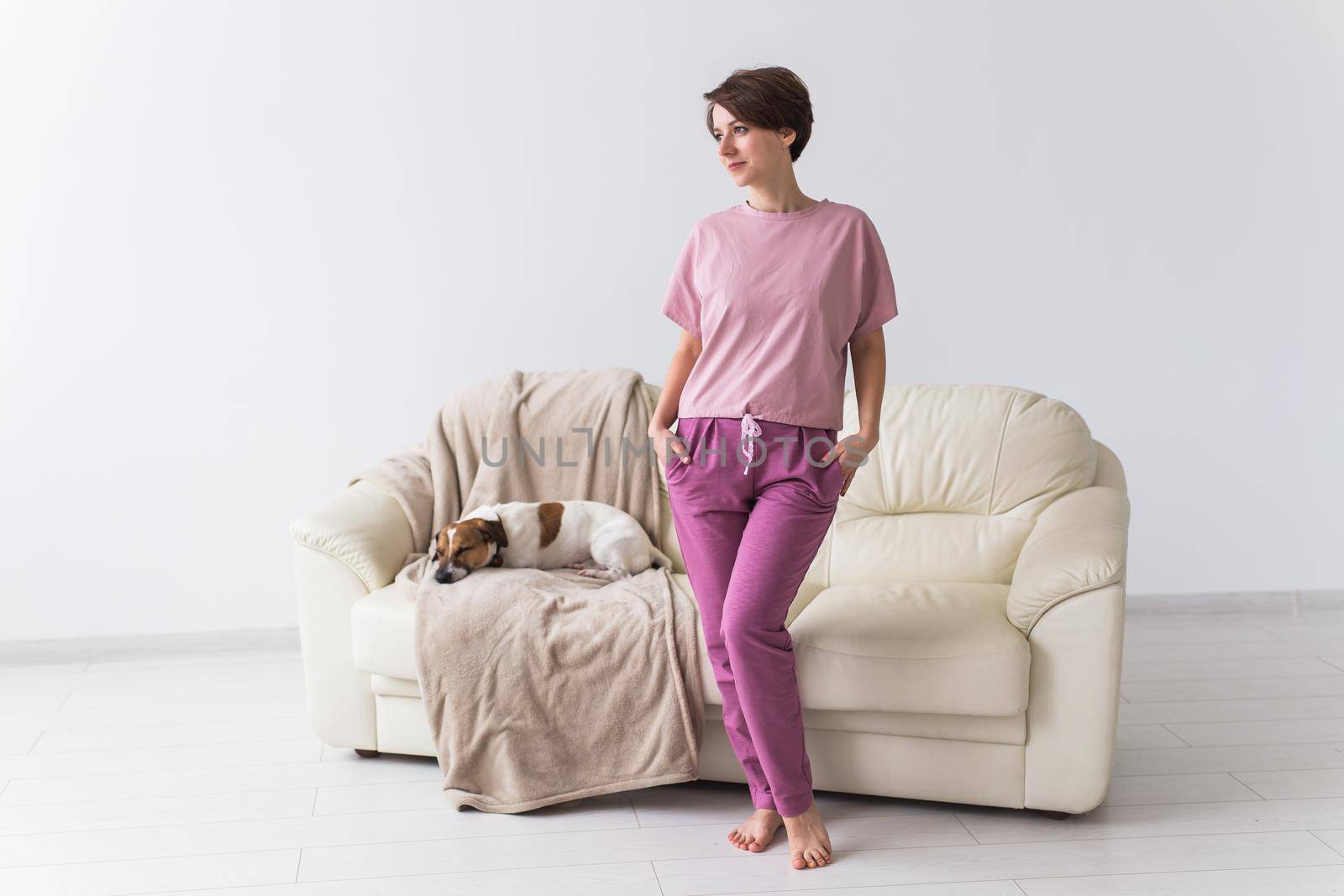 Young attractive woman dressed in beautiful colorful pajama posing as a model in her living room. Comfortable sleepwear, home relaxation and female fashion concept