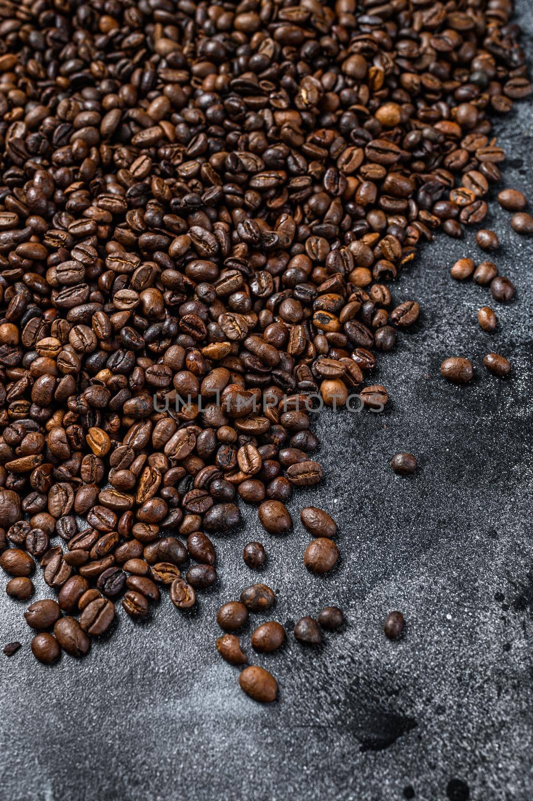 Roasted coffee beans on rustic table. Black background. Top view.