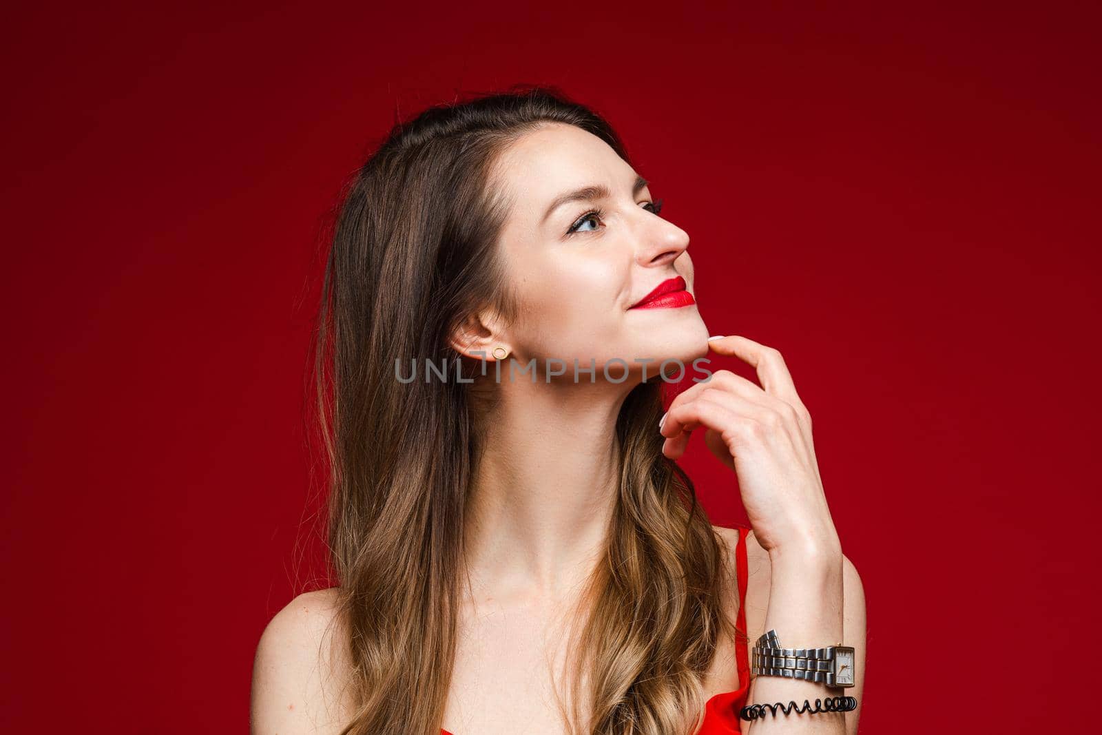 caucasian woman with attractive appearance thinks, picture isolated on red background