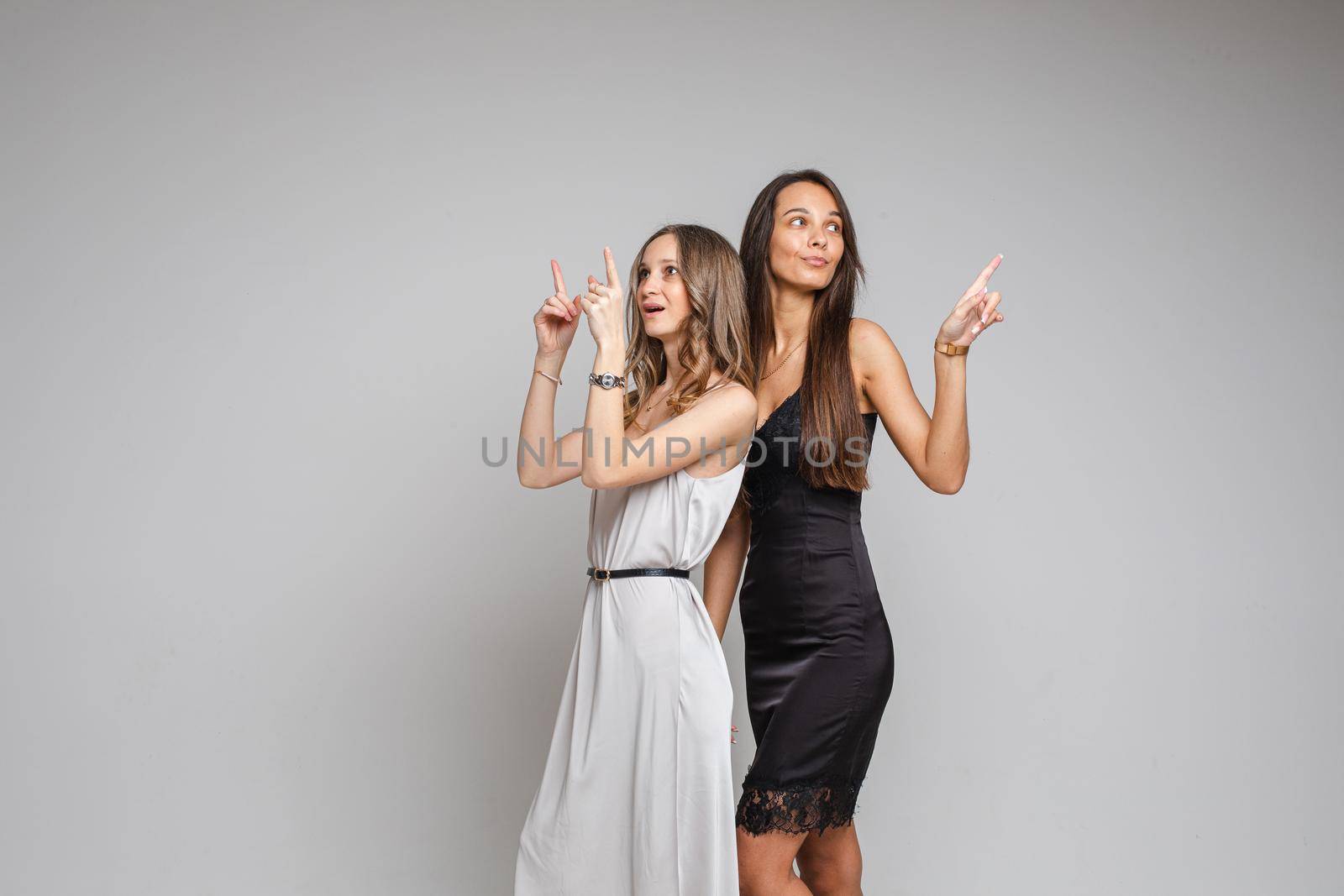 Beautiful young female friends posing in studio by StudioLucky