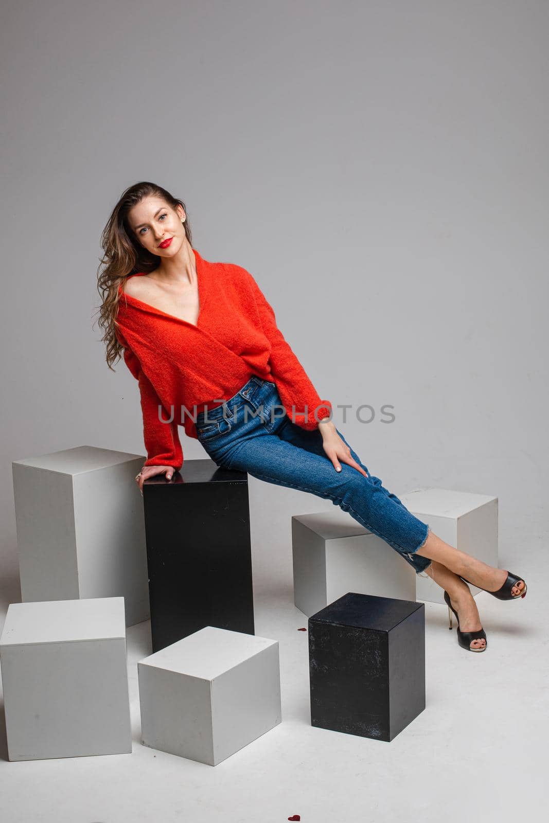 female model in re skirt and denim jeans poses for the camera on black and white cubes by StudioLucky