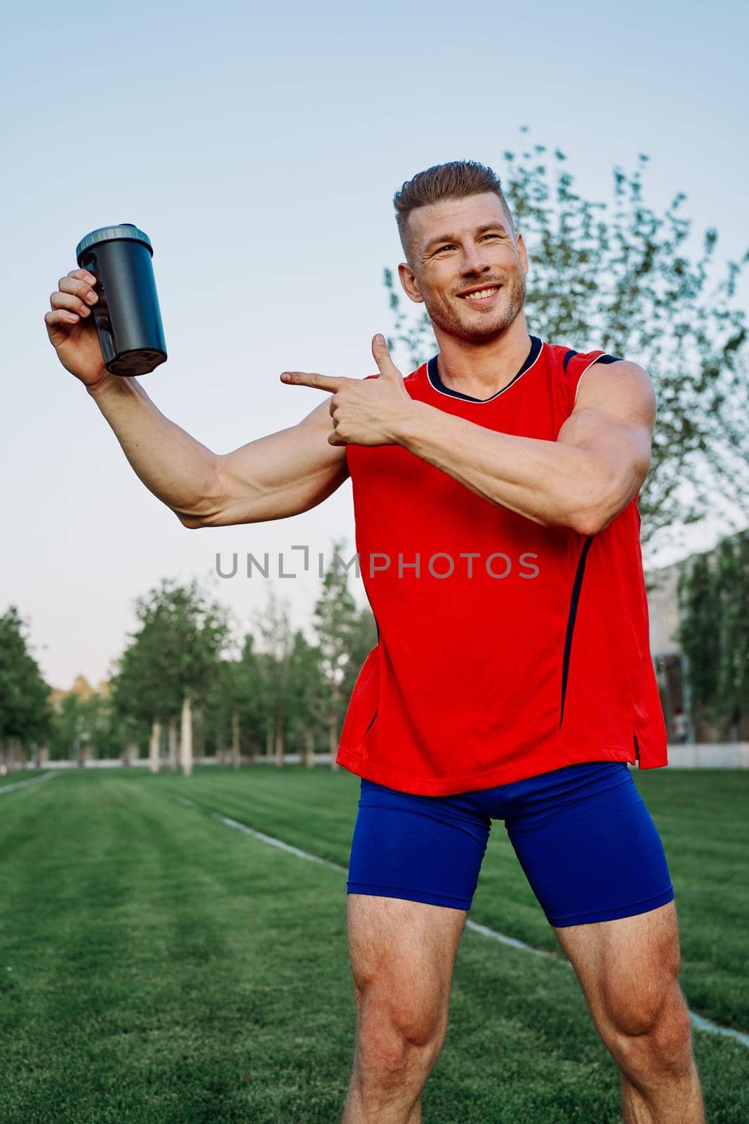 sporty man in the park outdoors glass with drink by Vichizh