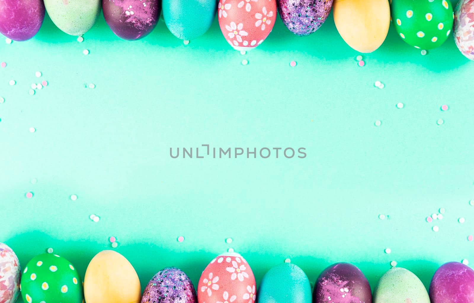 Colorful background with Easter eggs on green background. Happy Easter concept. Can be used as poster, background, holiday card. Flat lay, top view, copy space. Studio Photo by ArtCookStudio