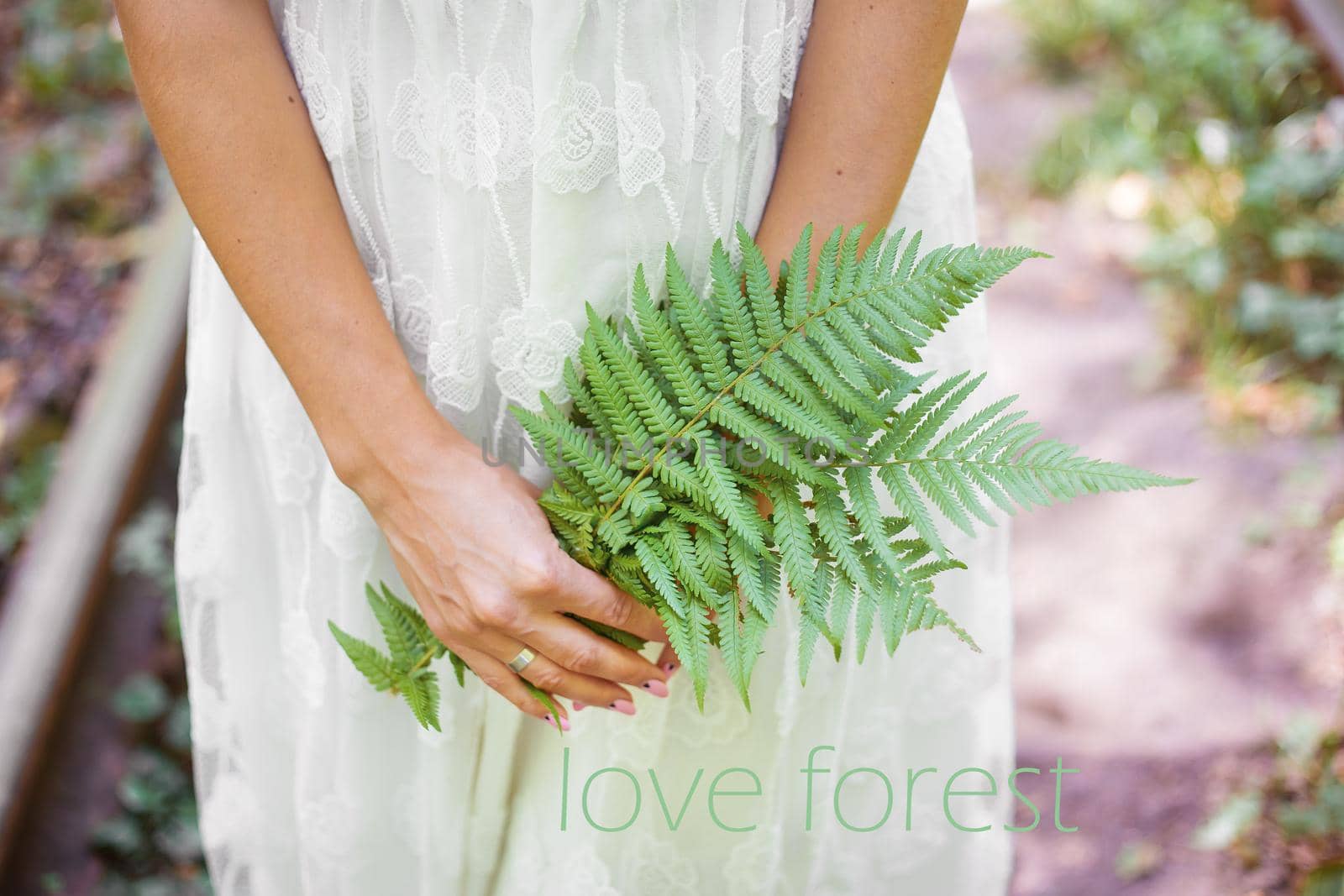 girl in a white dress, holding fern, wood inscription love by sfinks