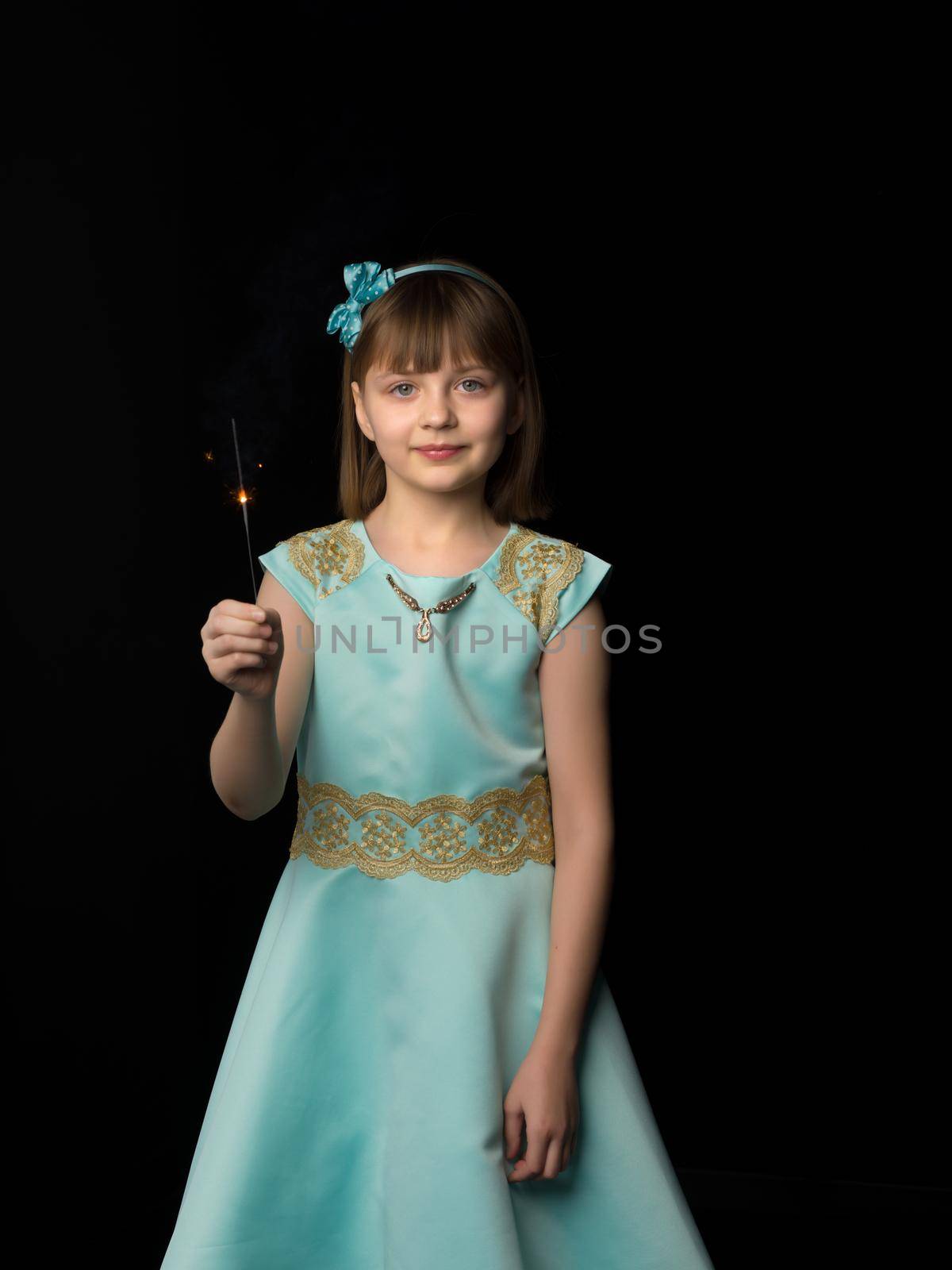 little girl holding firewors on black background