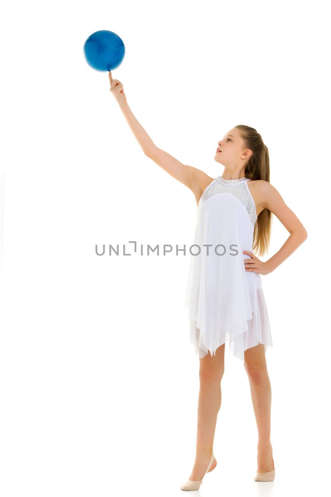 A charming little girl is engaged in fitness with a ball. The concept of gymnastics, health and sports. Isolated on white background.