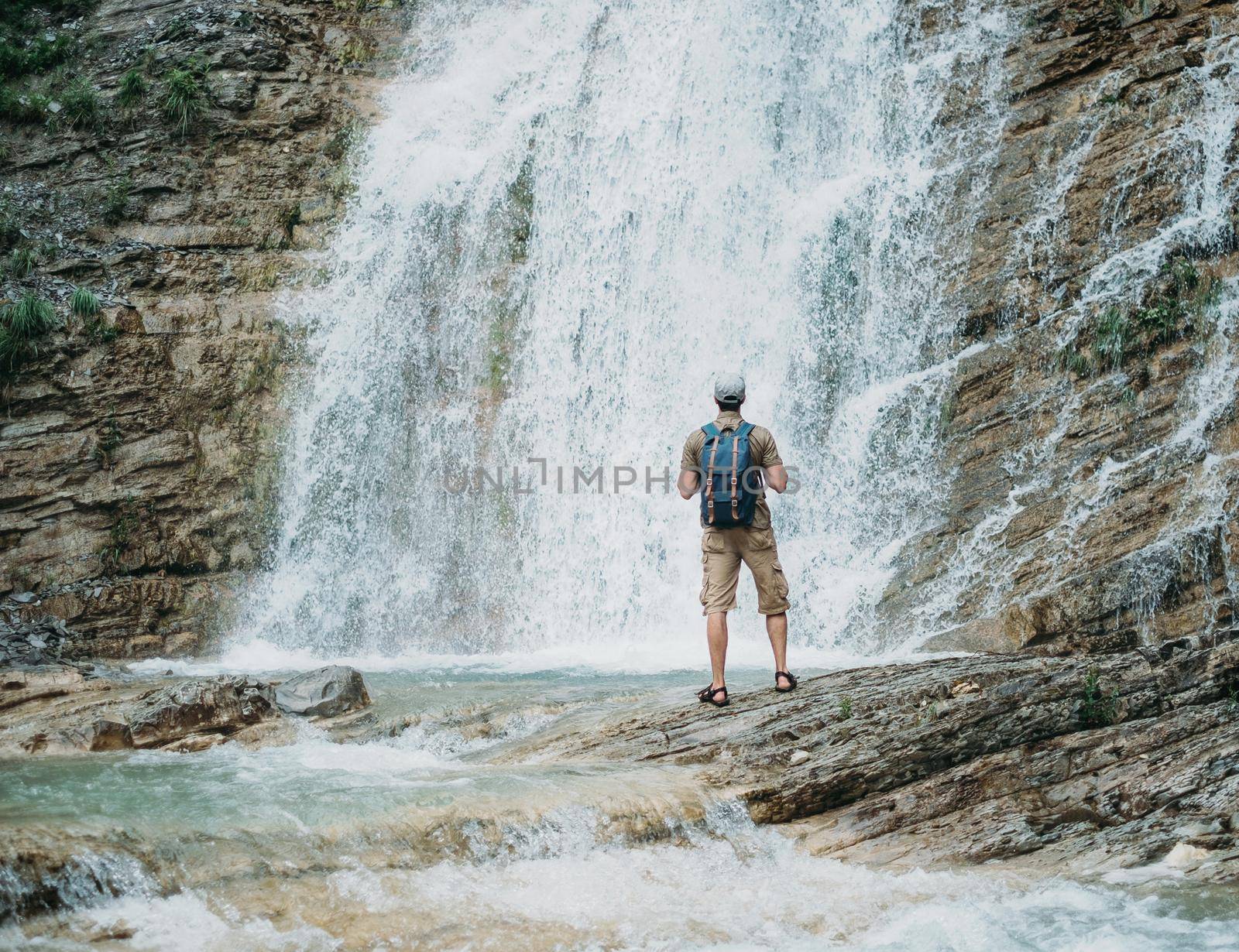 Explorer man and waterfall by alexAleksei