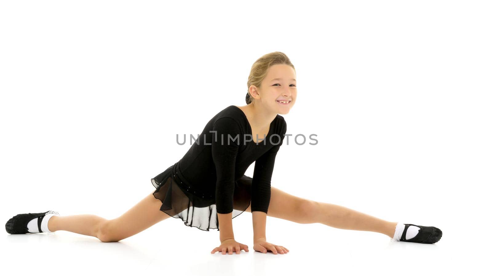 A little girl performs a gymnastic twine. The concept of fitness and sports. Isolated on white background.