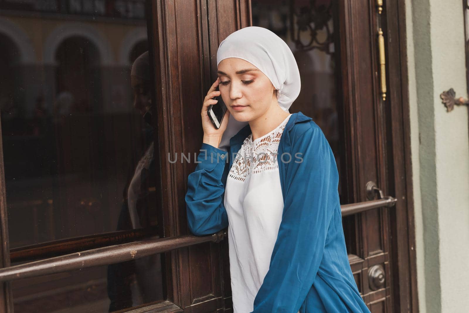 Portrait of young asian muslim student woman talking on the mobile phone outdoors.
