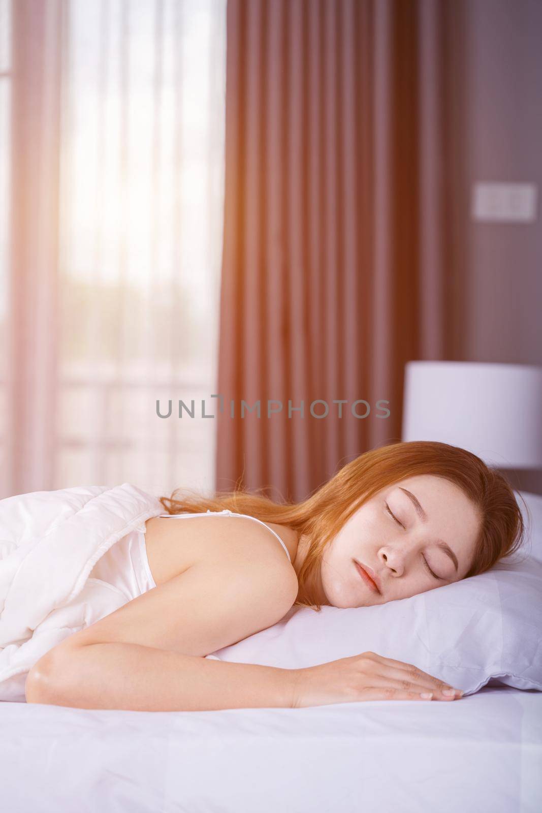 Woman sleeping on bed in bedroom with soft light