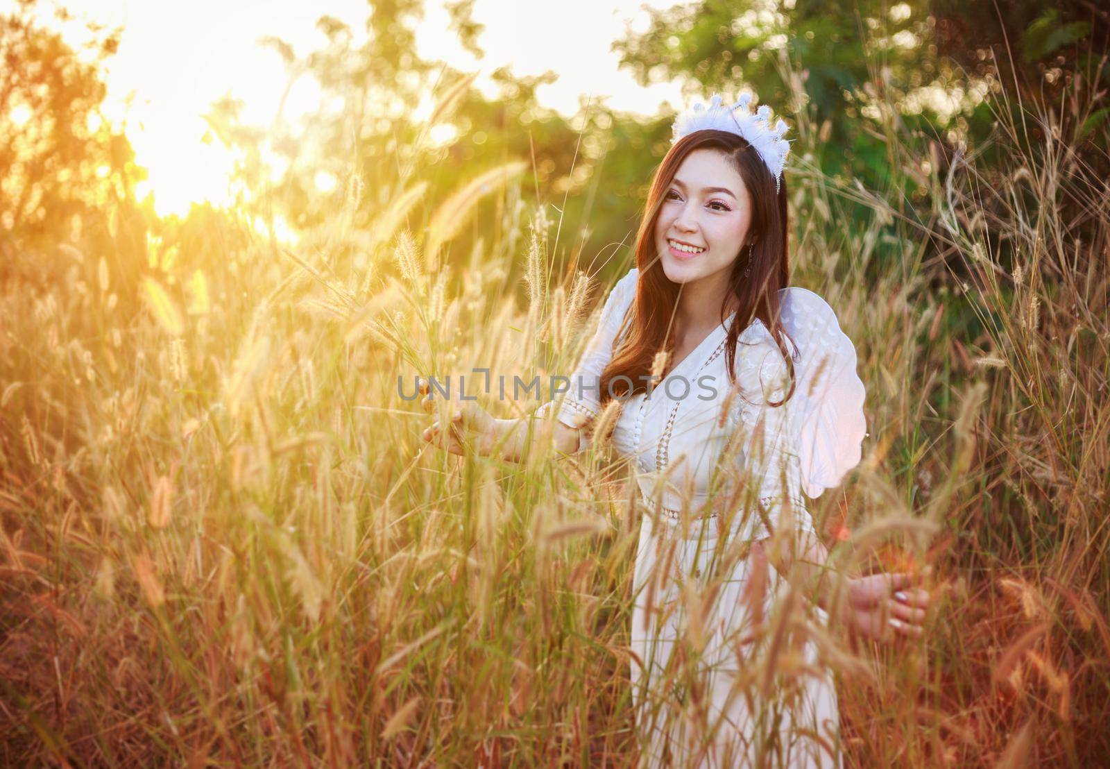 angel woman in a grass field with sunlight by geargodz