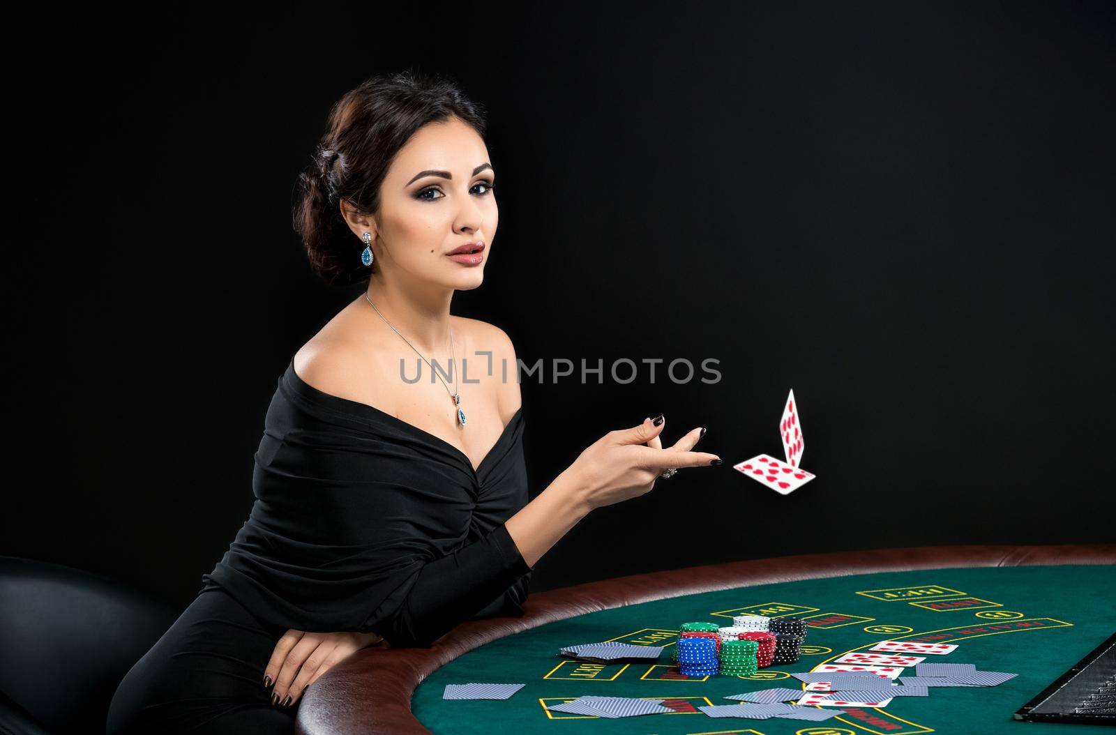 sexy woman with poker cards and chips. Female player in a beautiful black dress