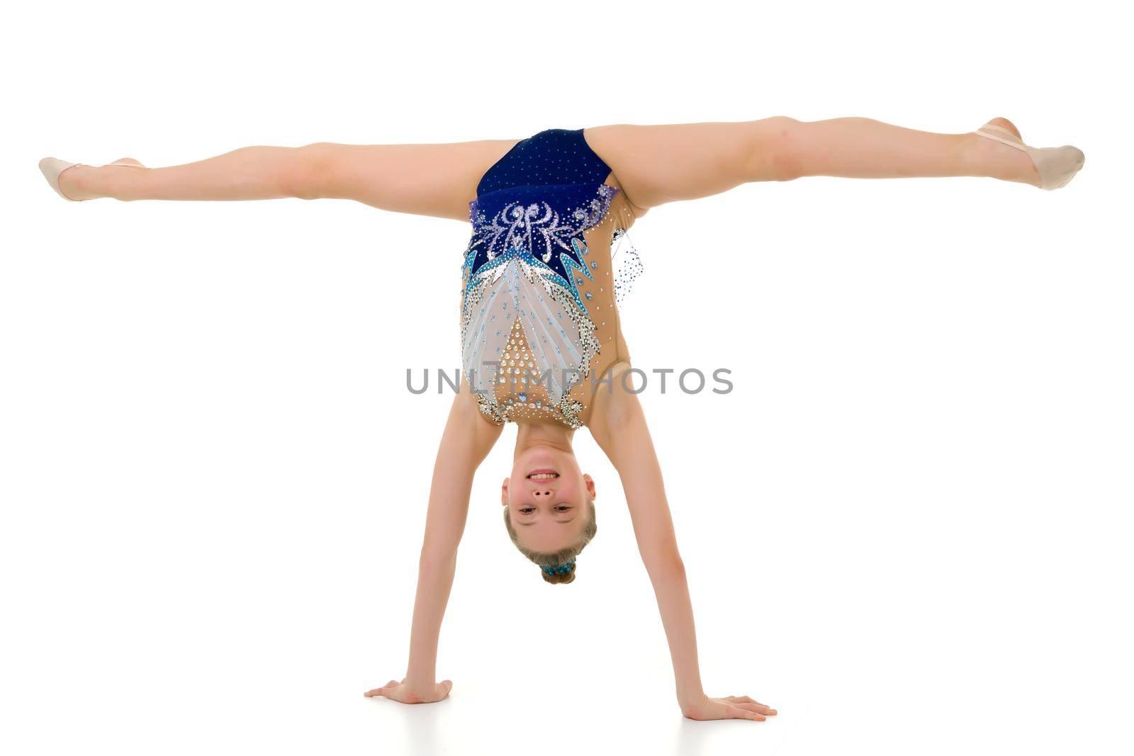 A slender girl gymnast, in a beautiful gymnastic leotard for competitions, performs a handstand. Concept for kids sport competition. isolated on a white background.