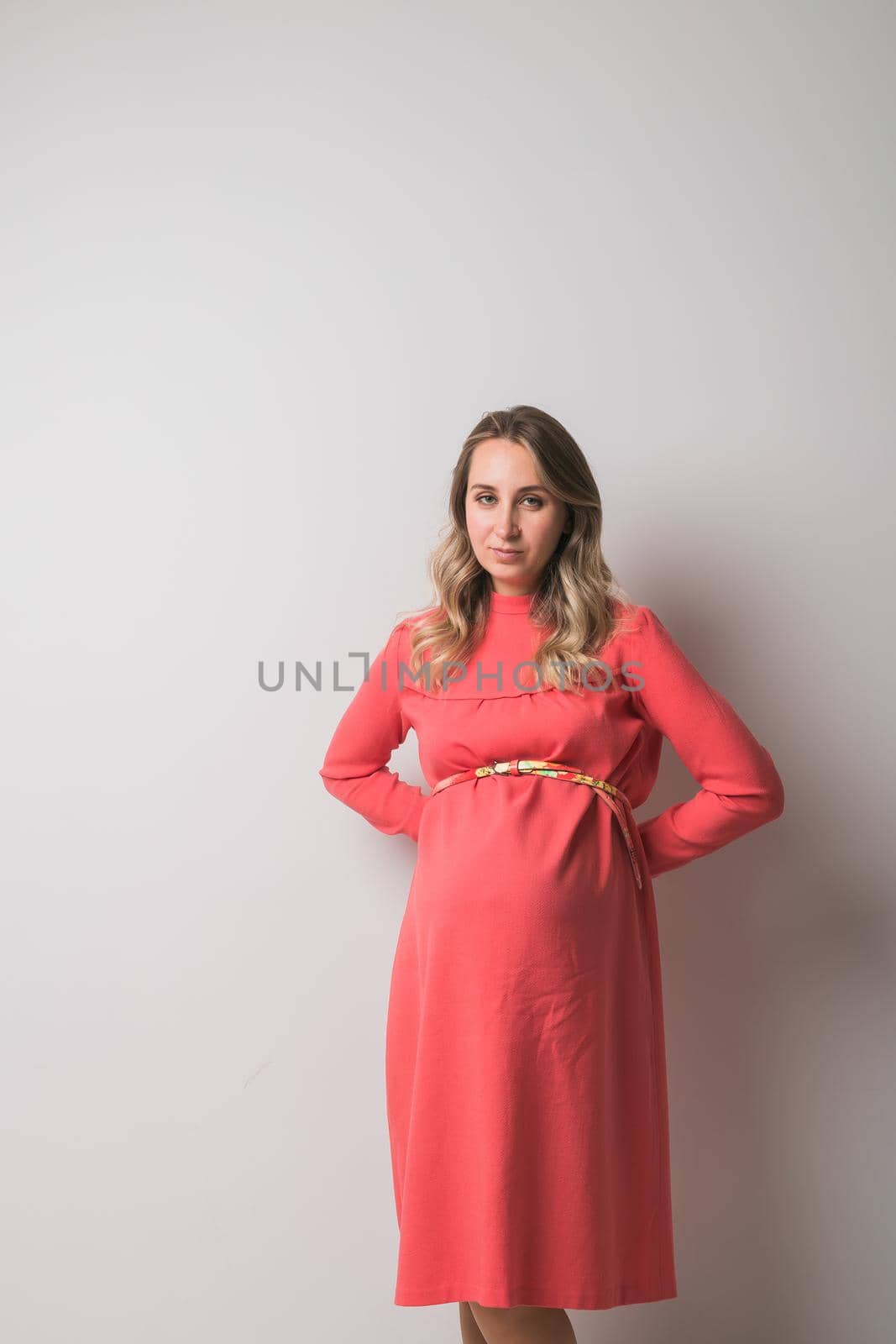 Pregnant woman on white wall background