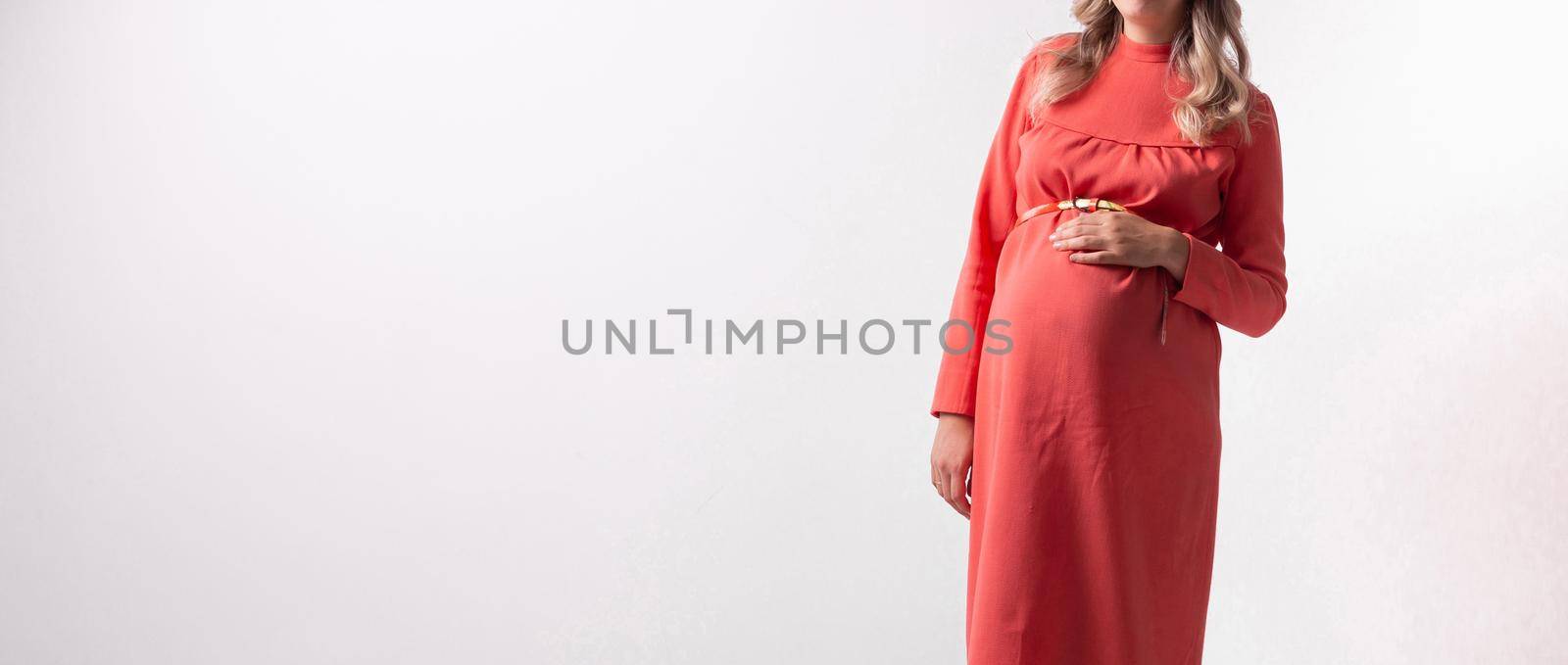 Pregnant woman on white wall background