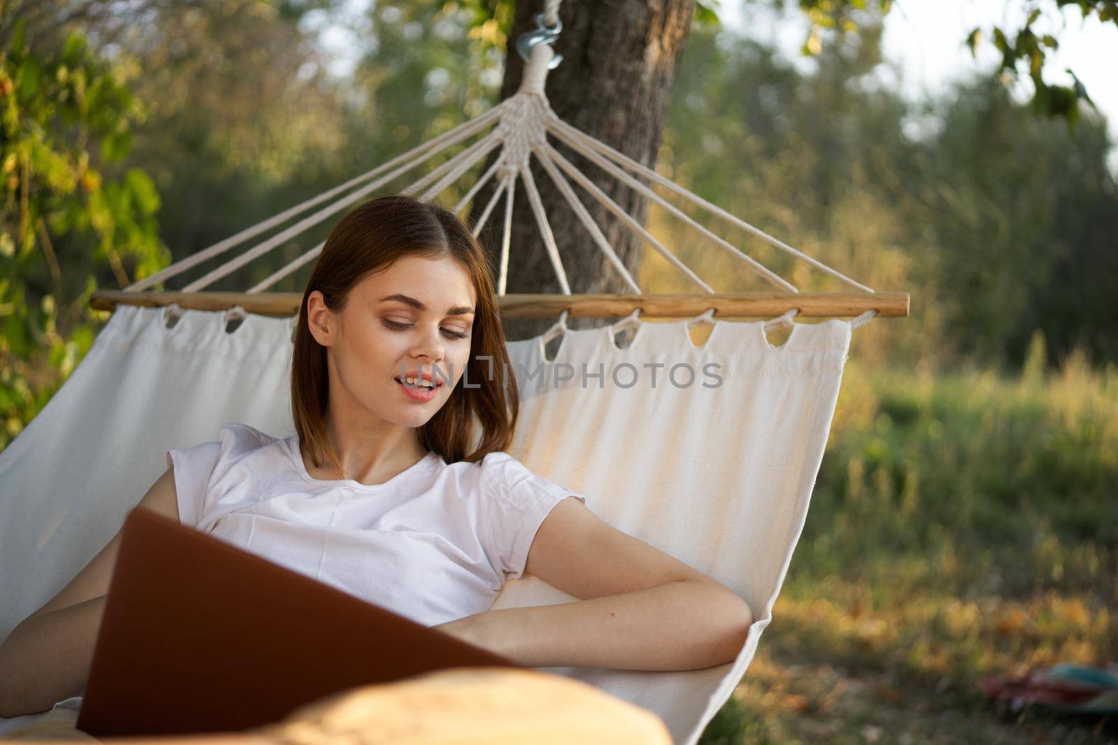woman with laptop and lies in a hammock vacation nature freelance. High quality photo