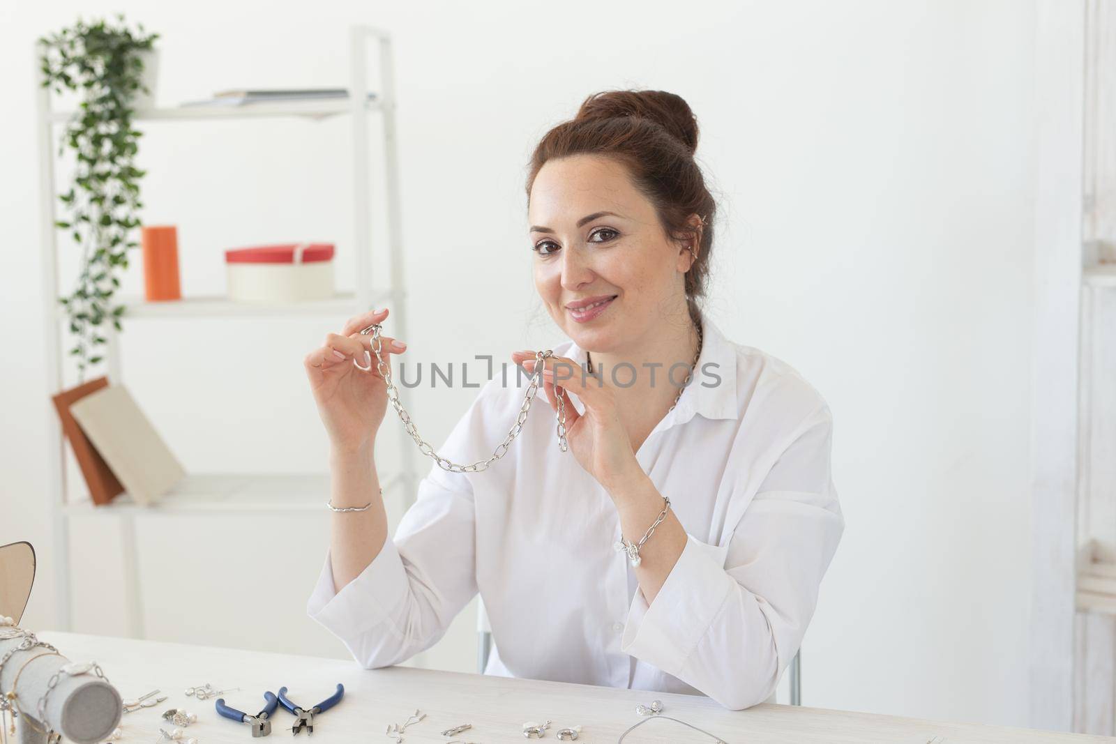 Professional jewelry designer making handmade jewelry in studio workshop. Fashion, creativity and handmade concept.