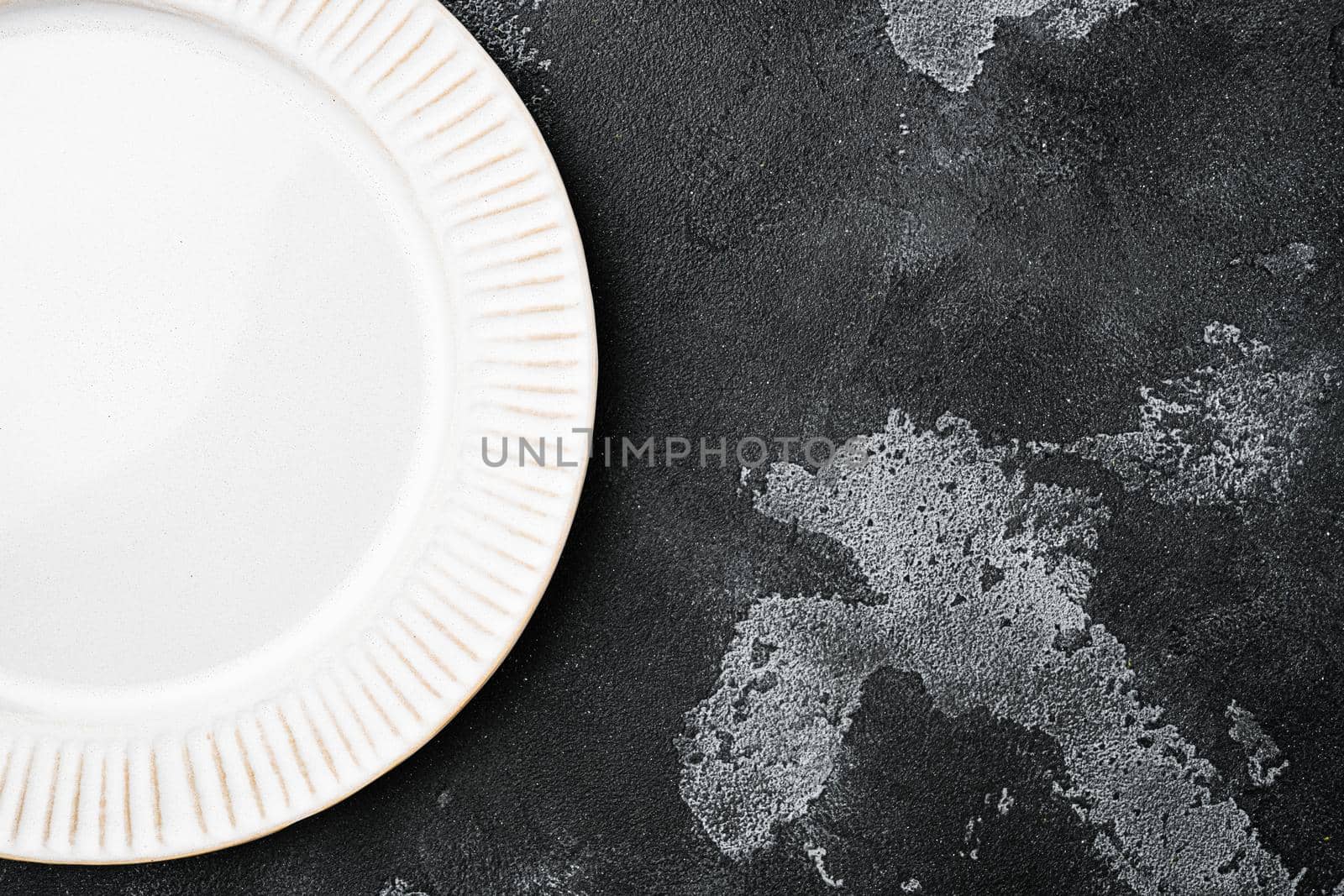 White plate empty utensil set with copy space for text or food with copy space for text or food, top view flat lay, on black dark stone table background