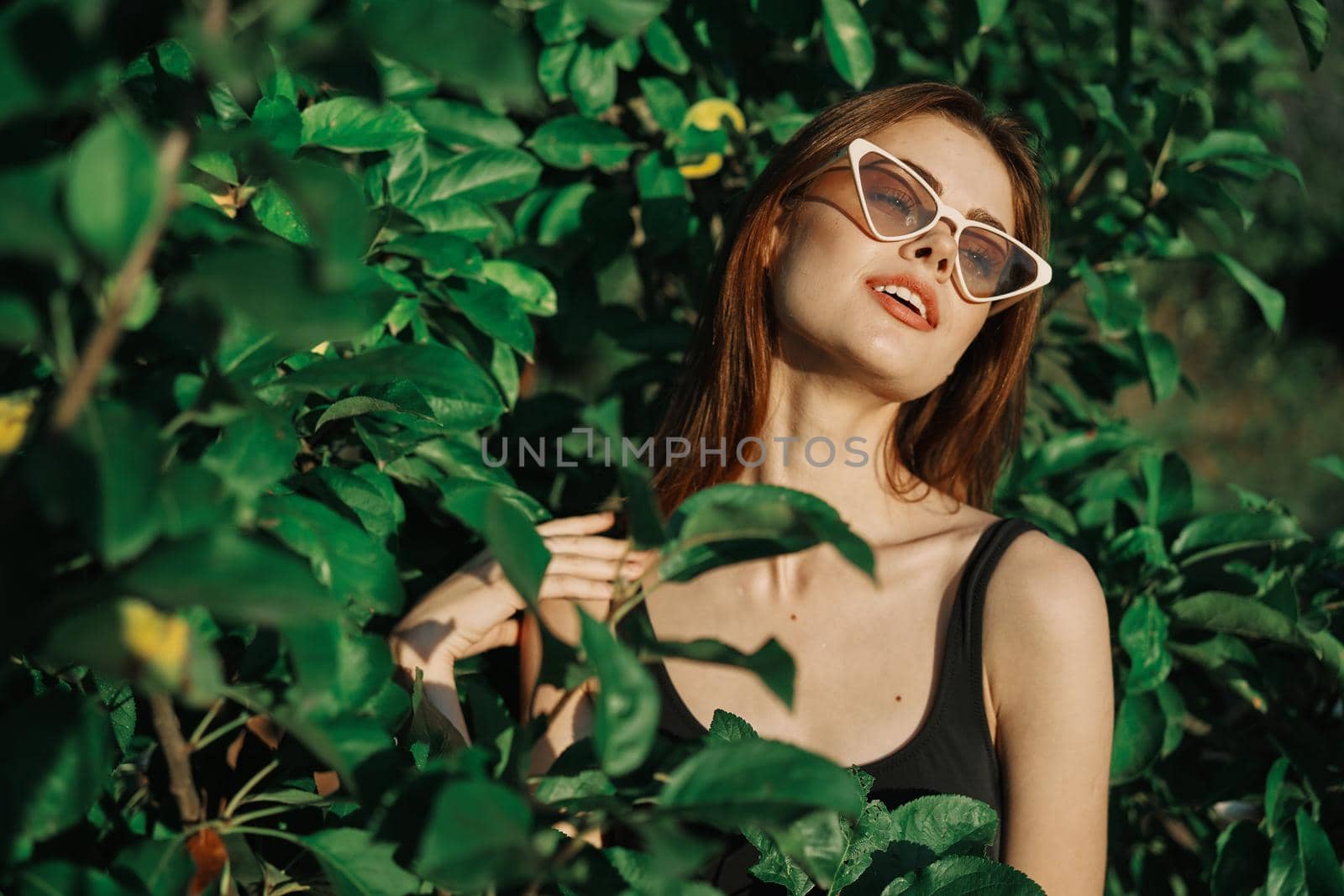 smiling woman wearing sunglasses green leaves nature fashion by Vichizh