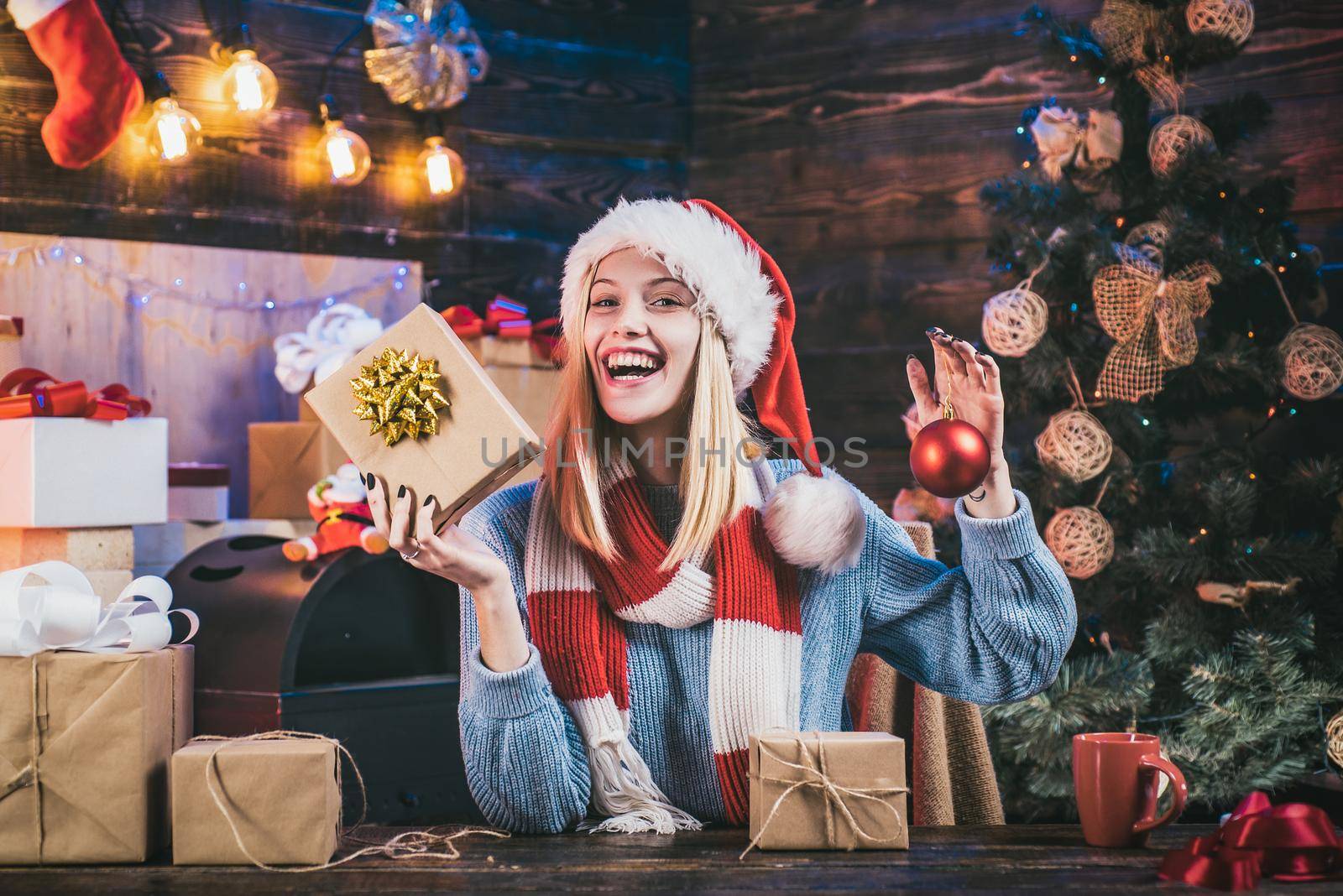 Positive human emotions facial expressions. Portrait of funny excited girl with gift indoors on Christmas tree. Expressions face