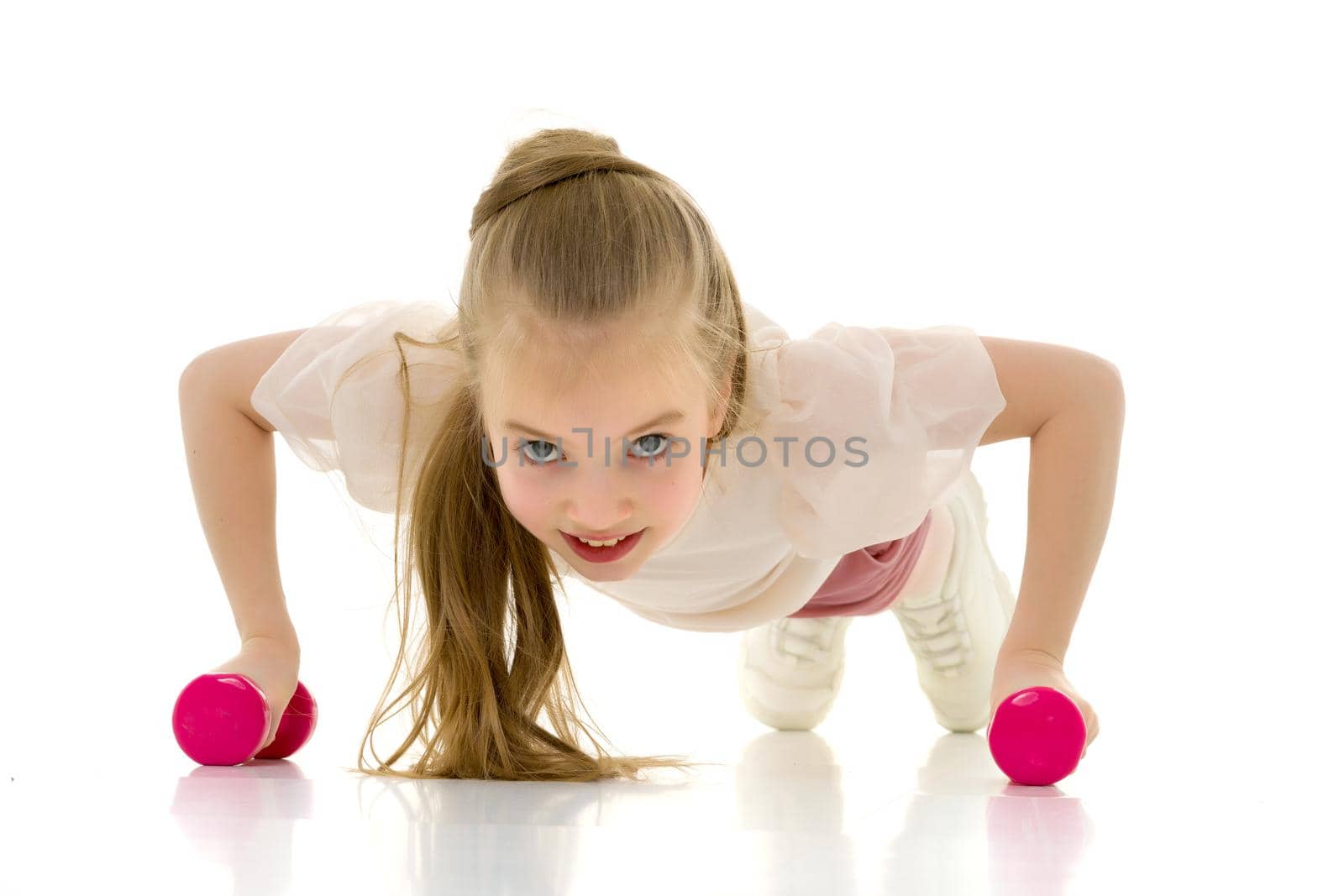 Little girl doing exercises with dumbbells. by kolesnikov_studio