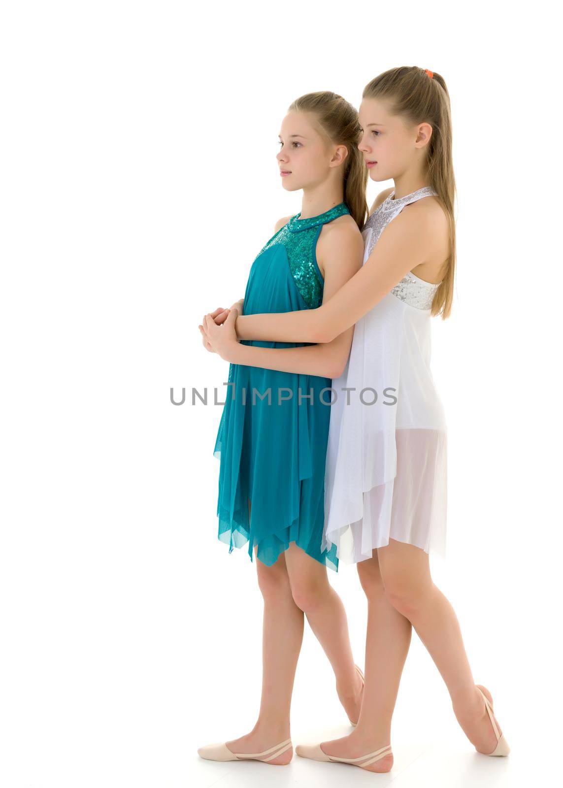 Pretty Gymnasts Performing Rhythmic Gymnastics Exercise, Two Beautiful Teen Sisters Dancing Wearing Sport Dresses, Two Girls Posing in Studio Against White Background