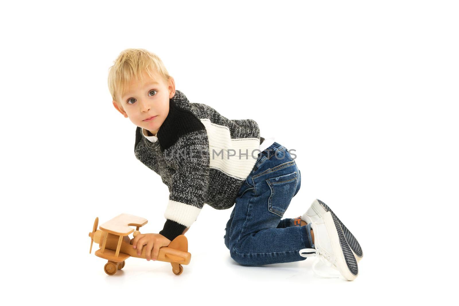 Happy kid boy plays with wooden toy airplane.Isolated on white background.