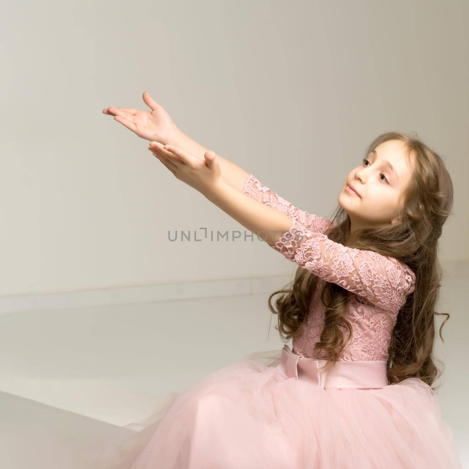Cute little girl stretches her arms forward. The concept of a happy childhood.On white background.