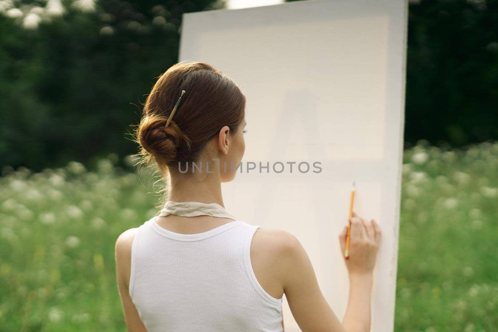 woman artist in aprons in nature draws a picture art. High quality photo