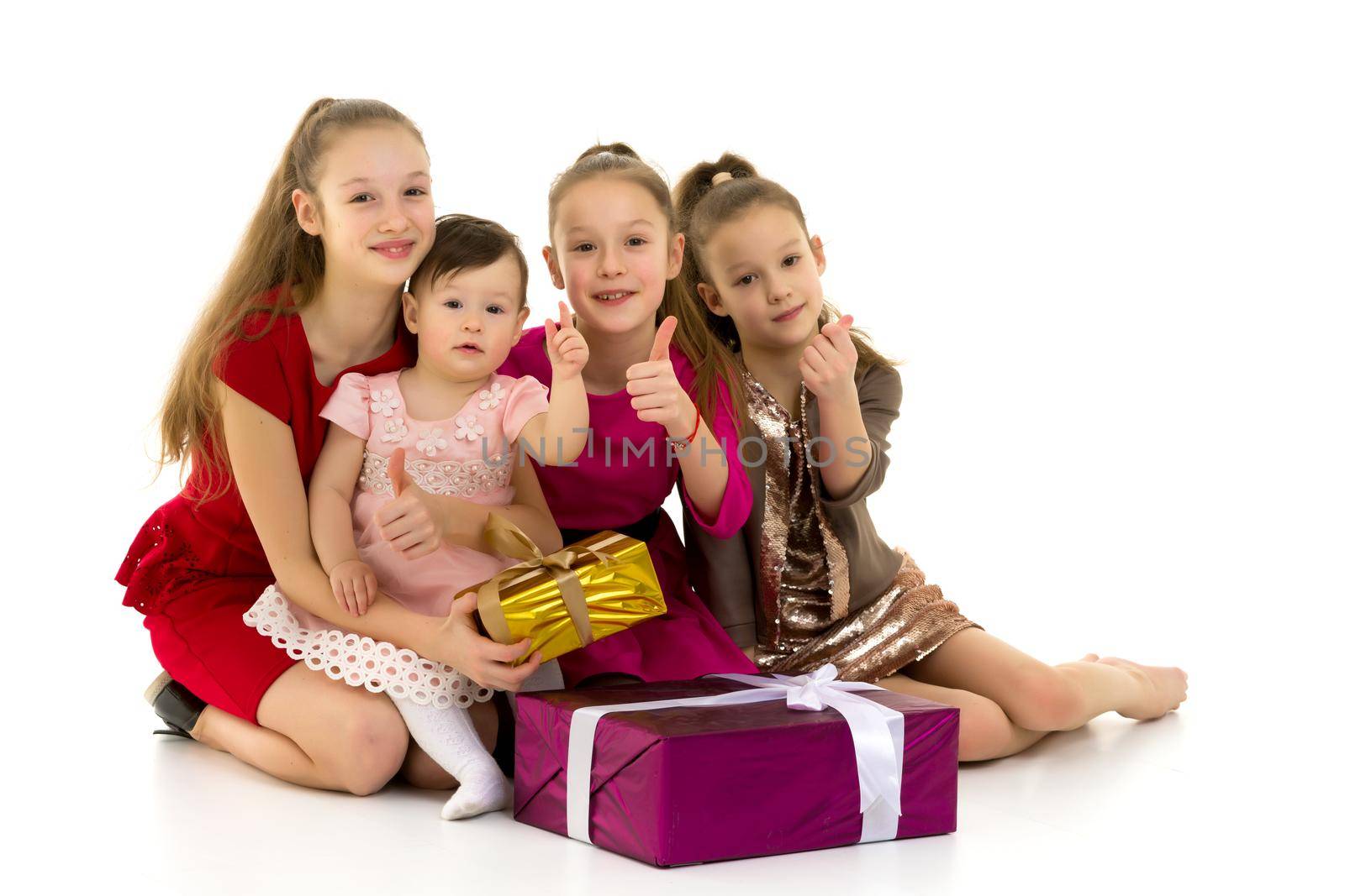 A company of little girls sits on the floor near gifts. Separate on a white background. The concept of family holidays, new year.