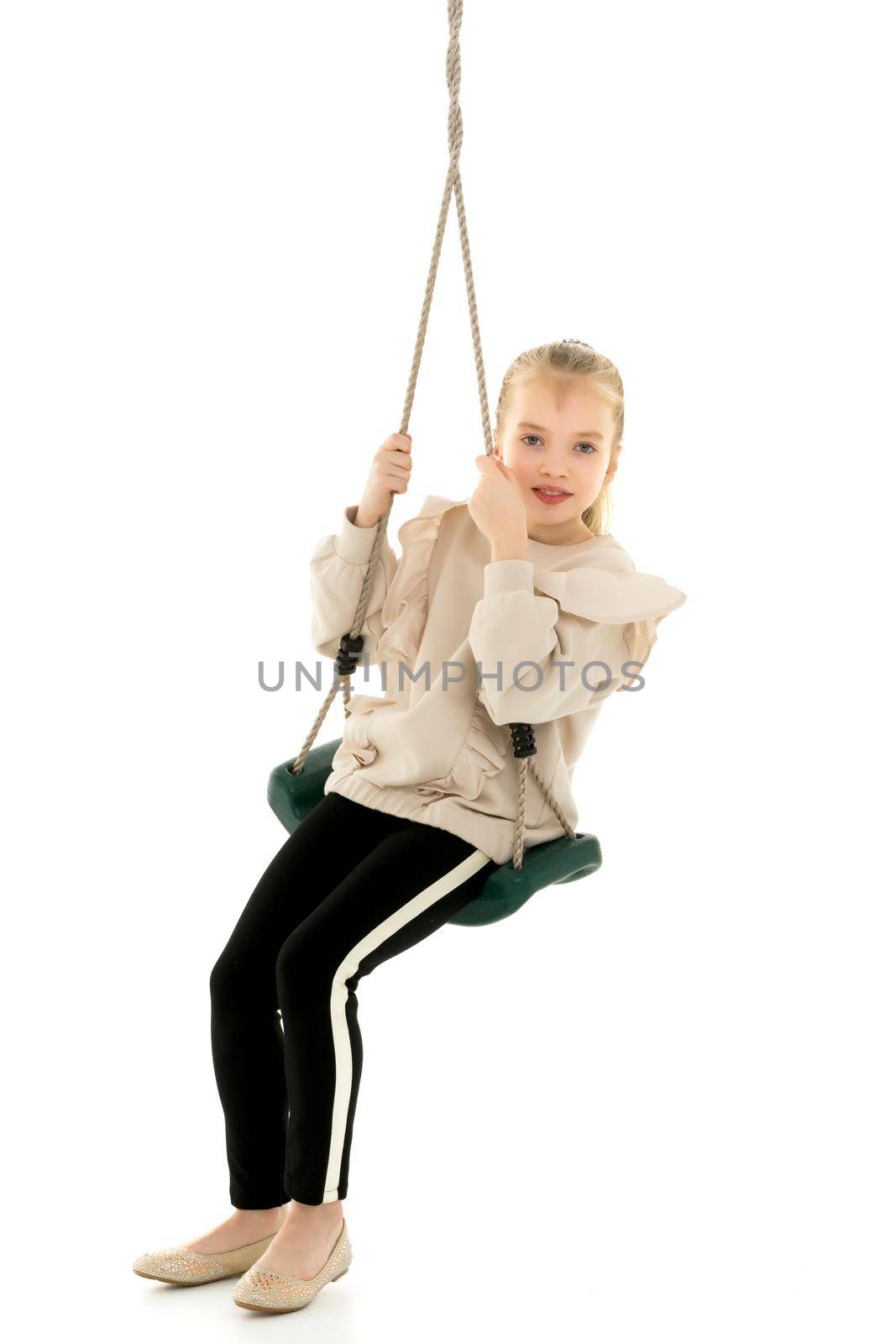 School-age teenage girl swinging on a swing. The concept of rest after class. Isolated on white background.