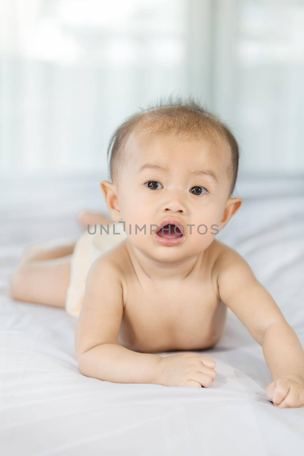 portrait of baby on a bed in bedroom at home