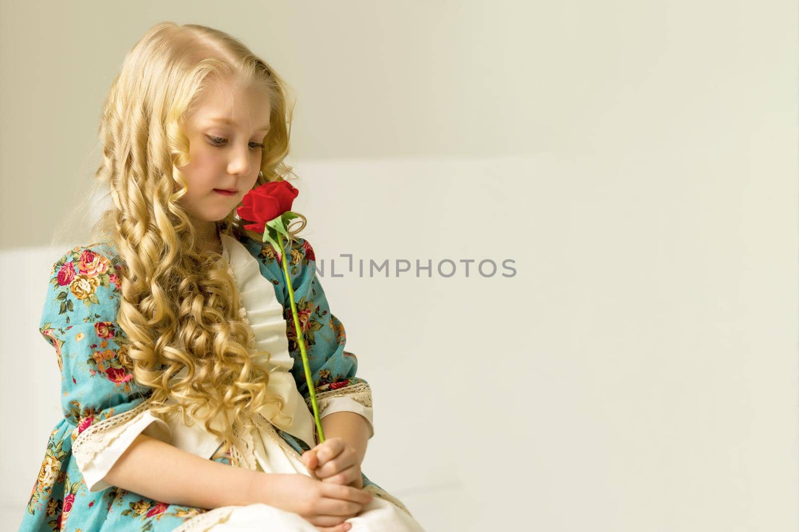 Beautiful little girl with a flower in her hands. The concept of beauty and fashion, happy childhood.