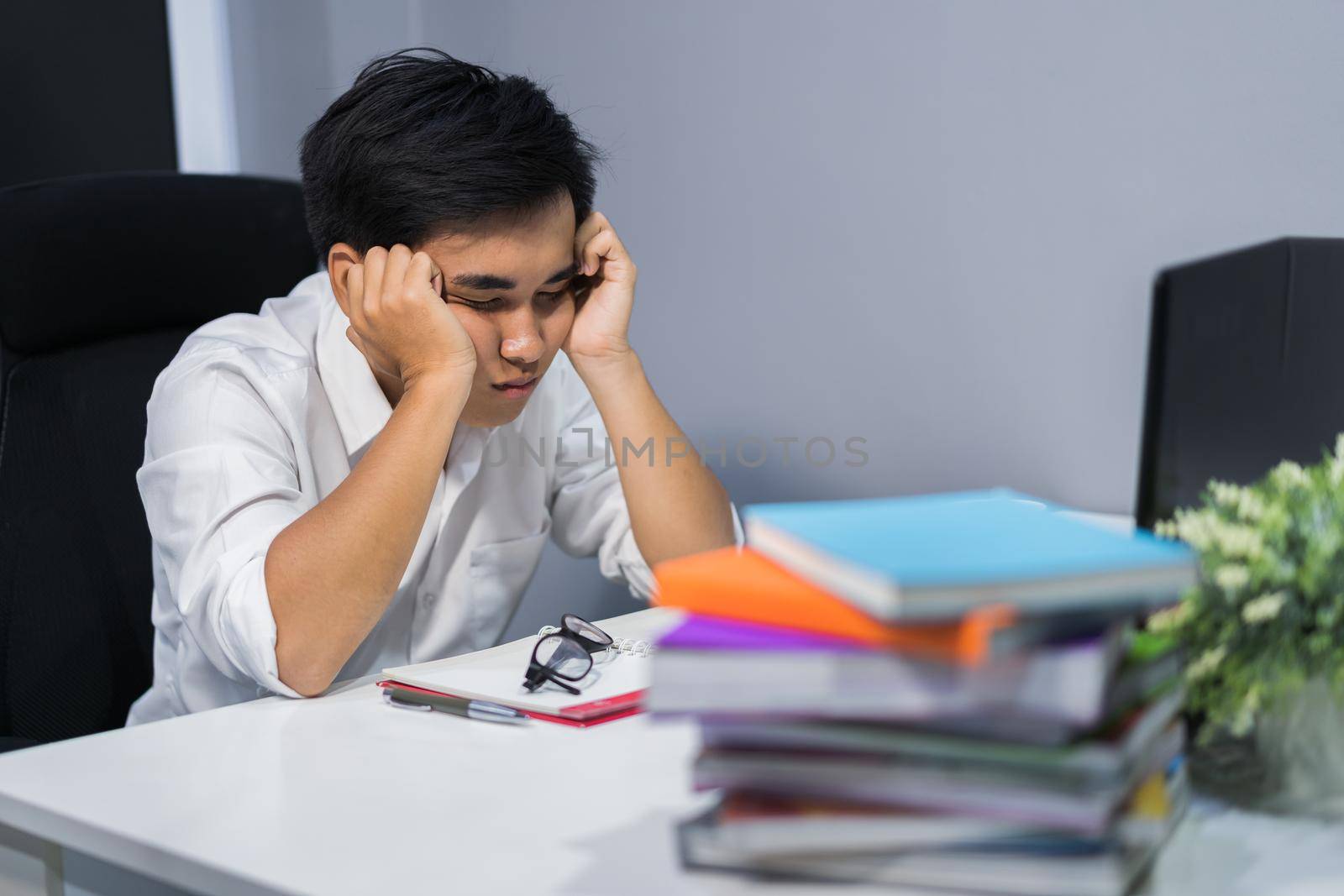 young student sitting and sleeping at desk with book and laptop  by geargodz