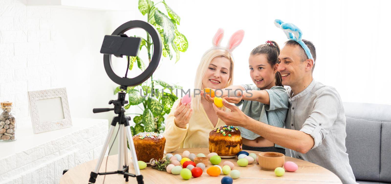 Father, mother and her child enjoy painting Easter eggs. Shop Online for happy easter decoration. Easter eggs - color egg assortment.