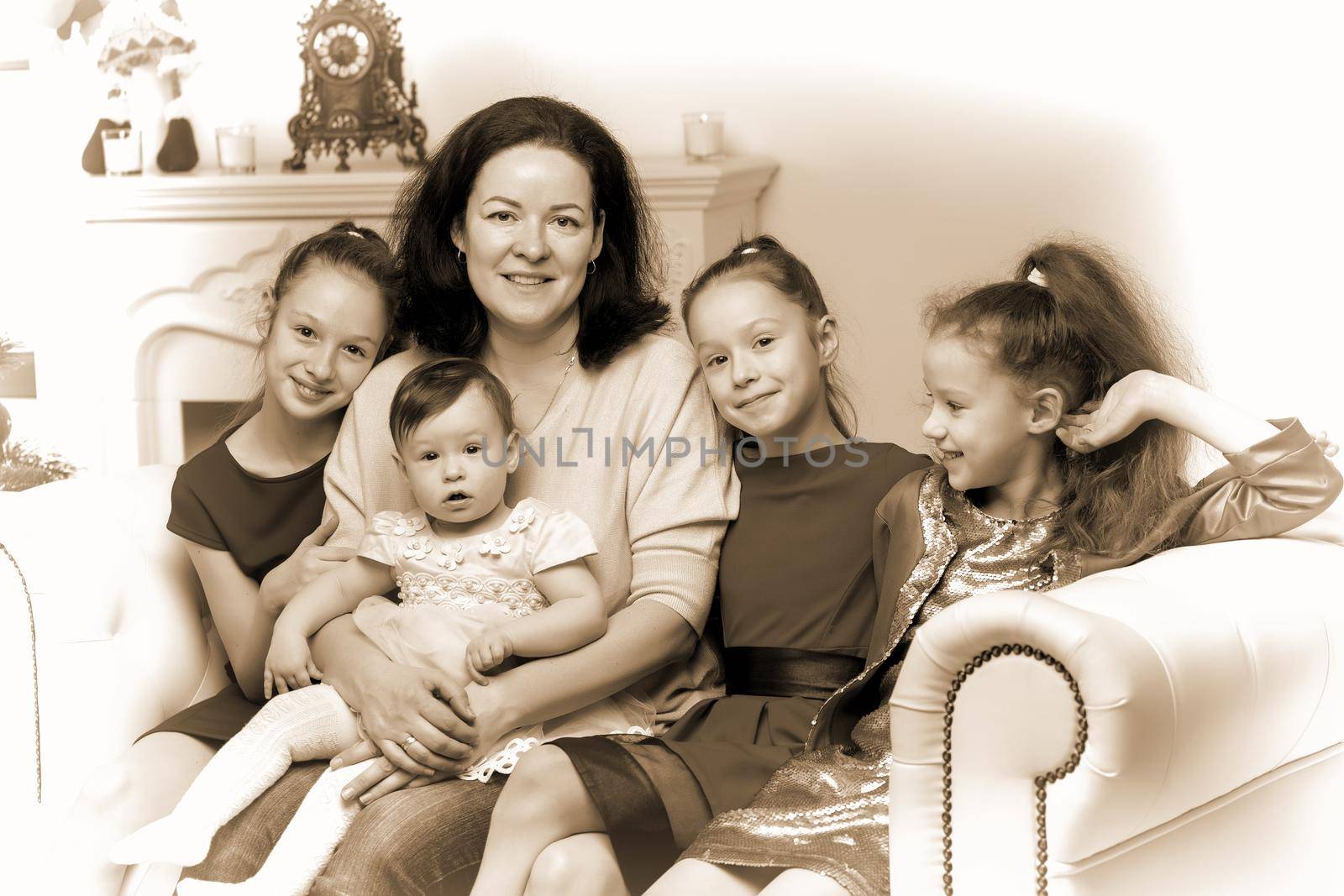 Happy Family Portrait of Mother with Three Daughters, Cheerful Parent and Three Sisters Sitting on the Sofa in the New Year Interior near Christmas Tree, Black and White Edition