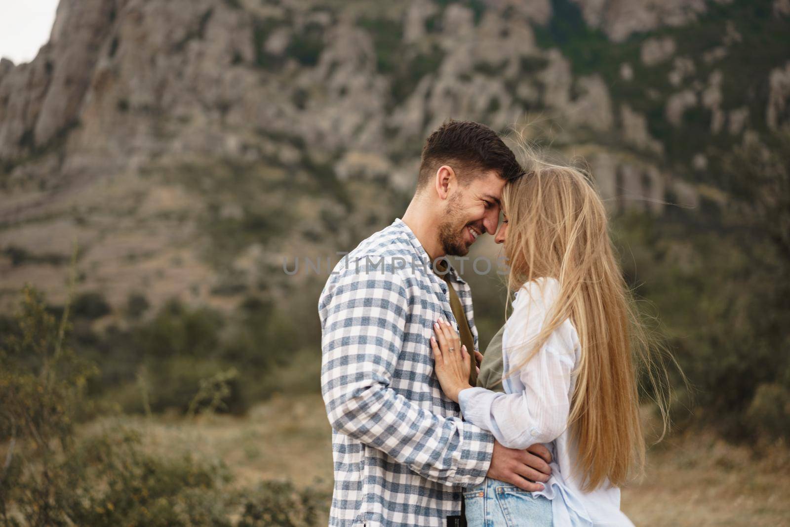 Happy loving couple hiking and hugging in mountains, close up