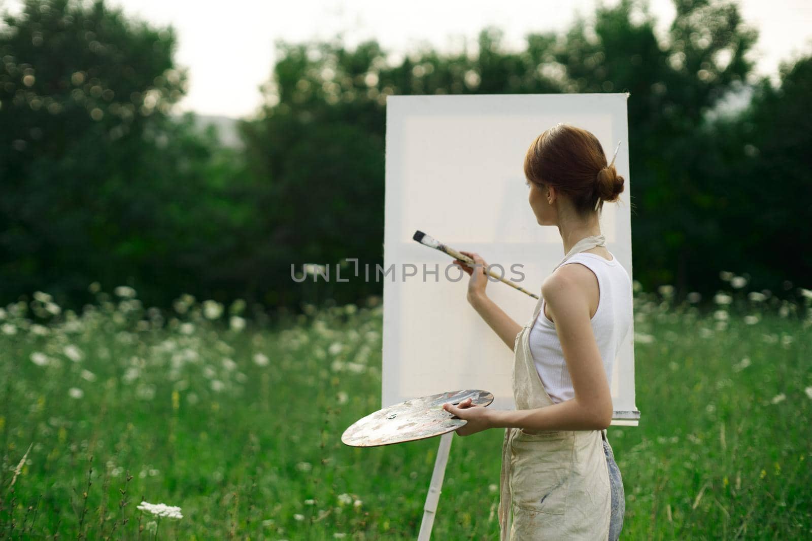 woman artist outdoors easel drawing creative landscape. High quality photo