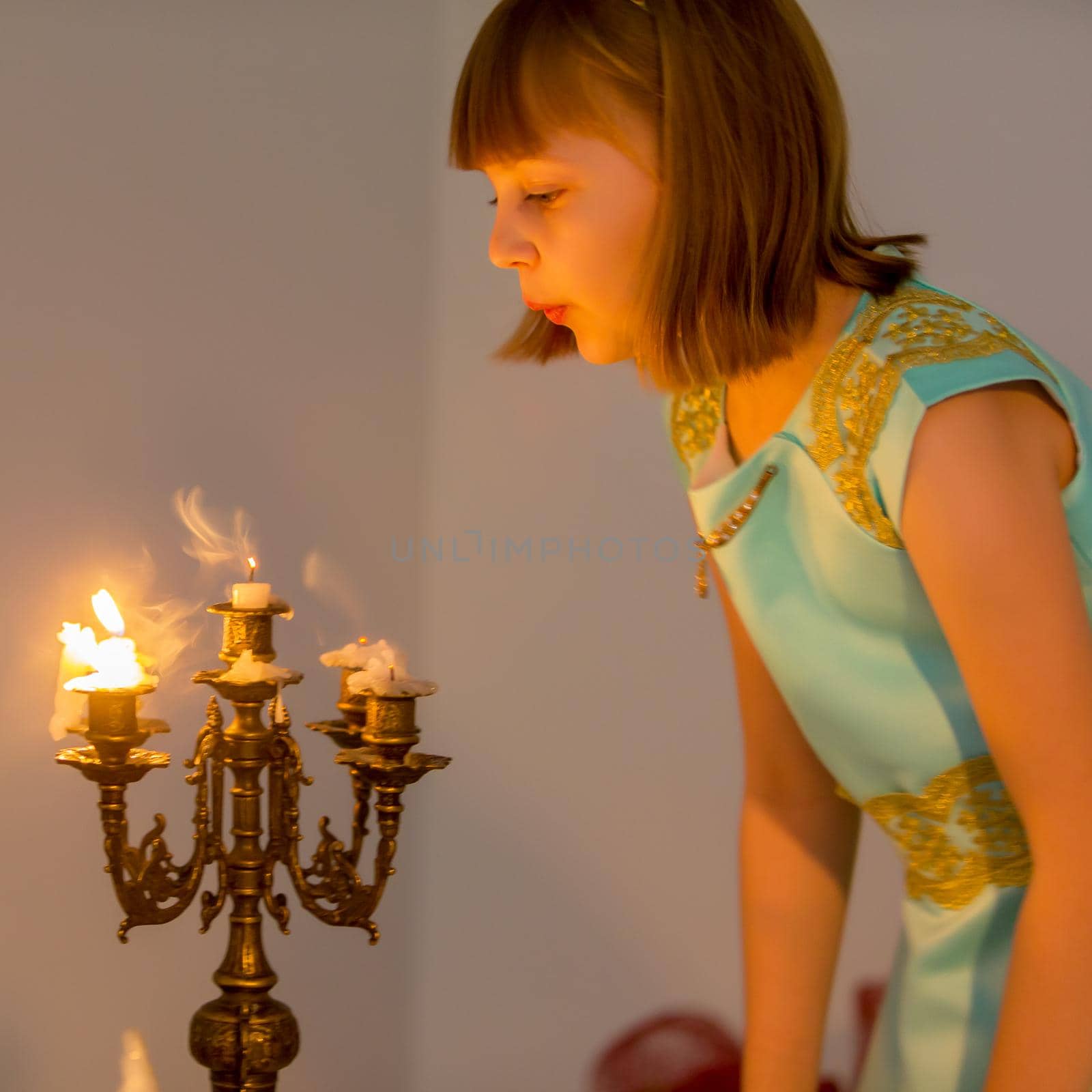 Beautiful little girl blowing on candles. Holiday, christmas, birthday concept