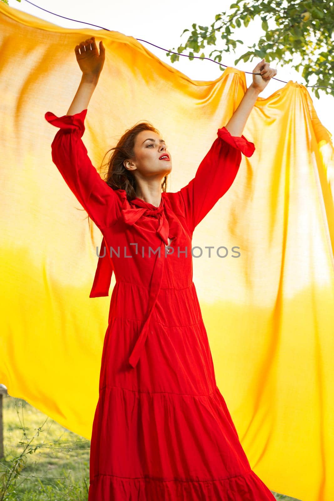 festively outdoors yellow cloth on the background of posing red dress by Vichizh