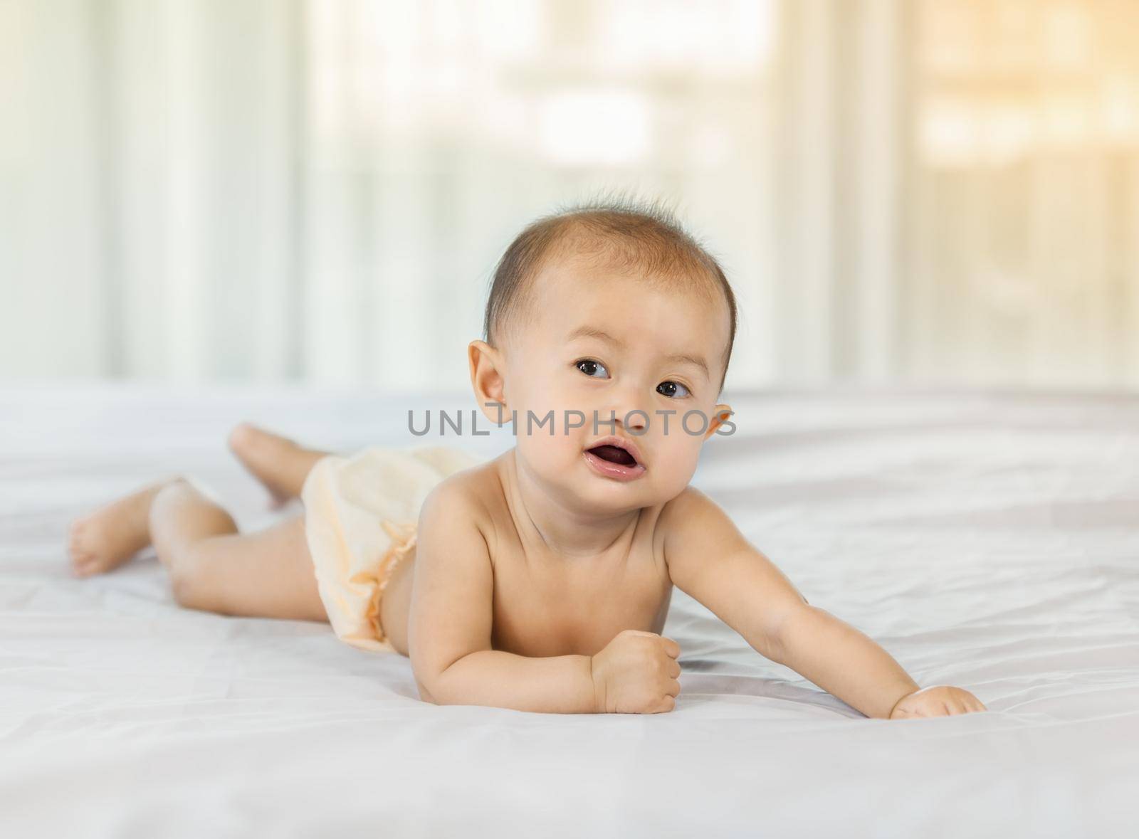 portrait of baby on a bed in bedroom at home