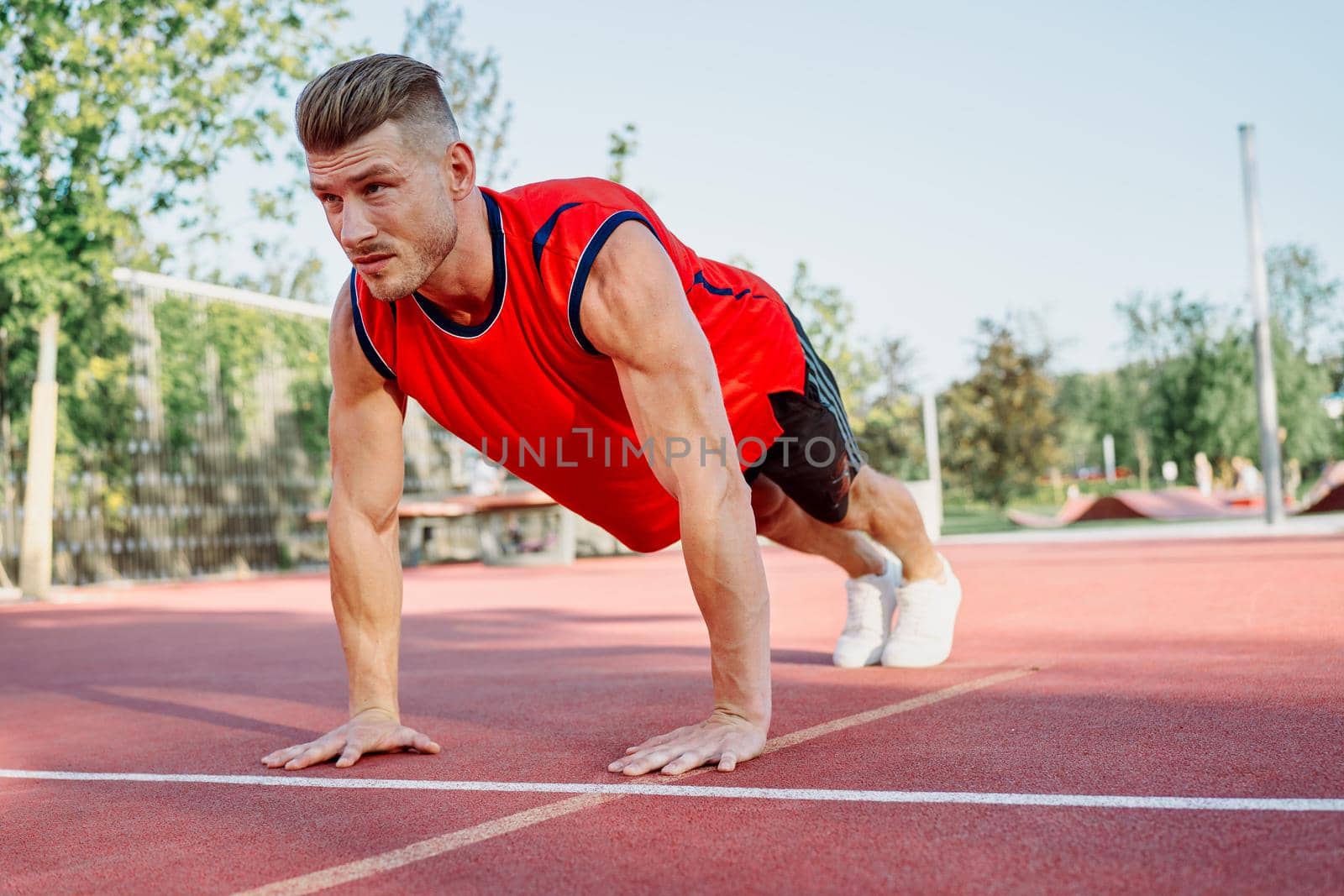 Muscled athletic men on the sports ground workout exercises. High quality photo