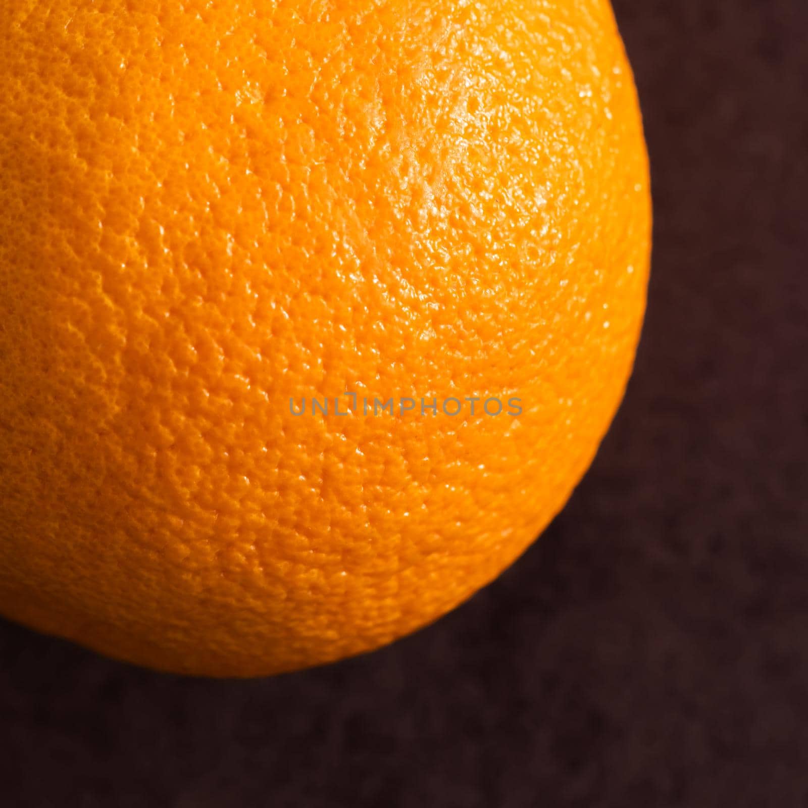 Ripe orange on a brown background. Close up view.