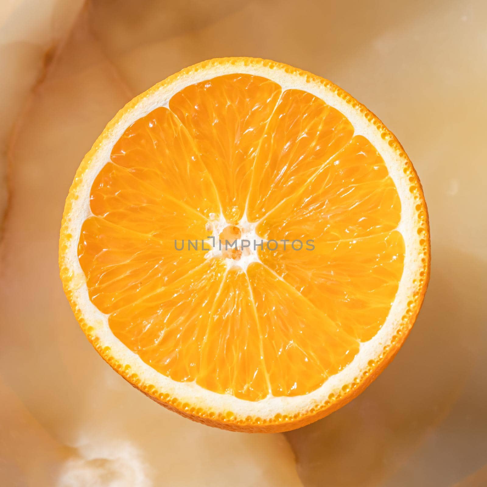 Half of orange on marble onyx background. Round fruit with clipping path.